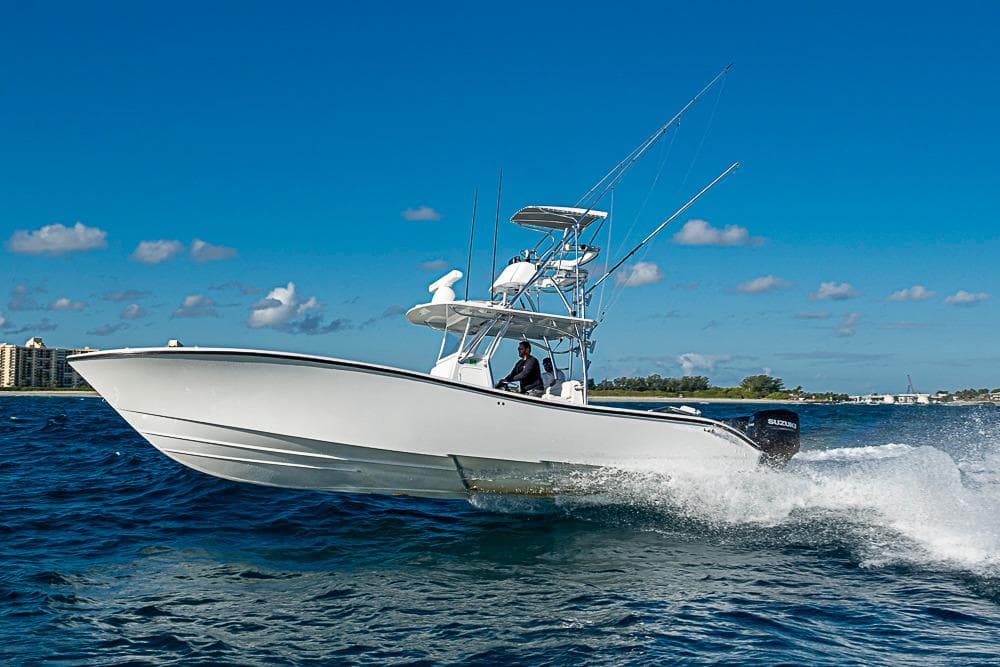 2002 Yellowfin 36 Offshore boat cruising on open water under clear blue sky.