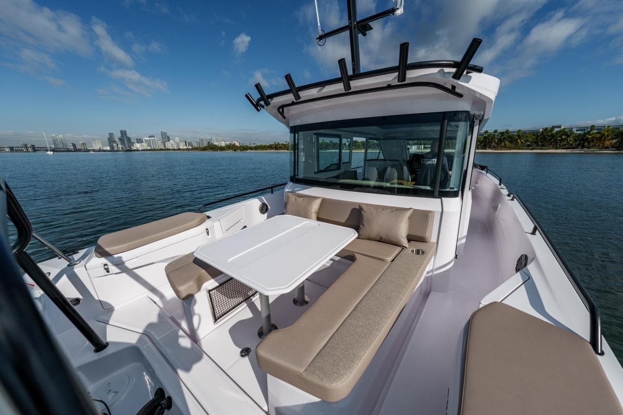 2026 Axopar 37 XC Cross Cabin boat with spacious seating and table on calm water.