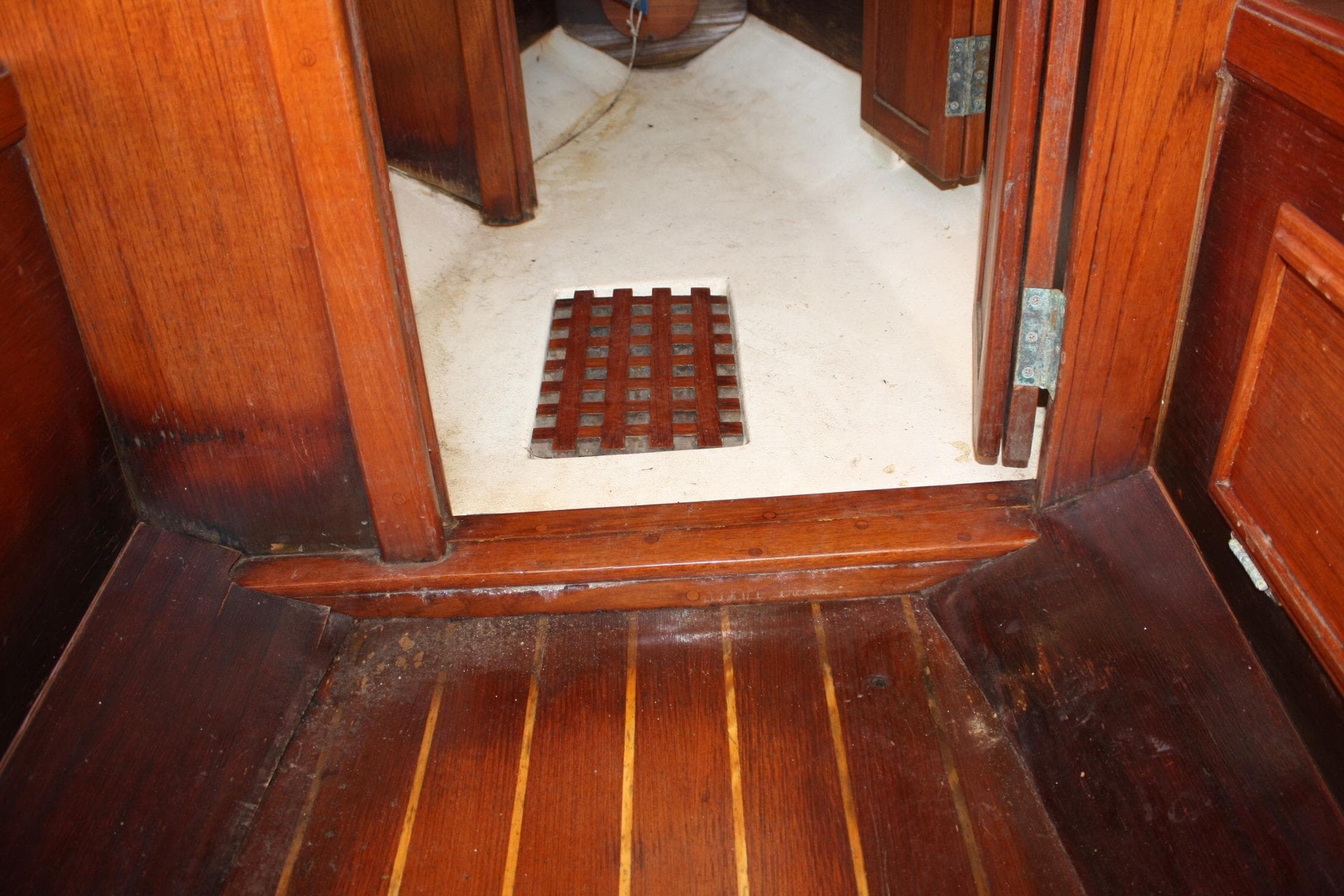 Interior of 1983 Cape Dory 27 sailboat with wooden flooring and cabin entrance.