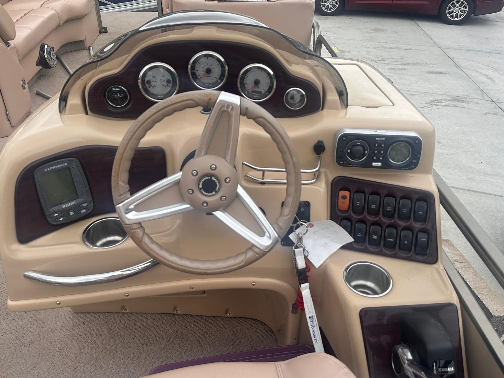2008 Godfrey Sanpan 2500 RE boat dashboard with steering wheel and control panel.