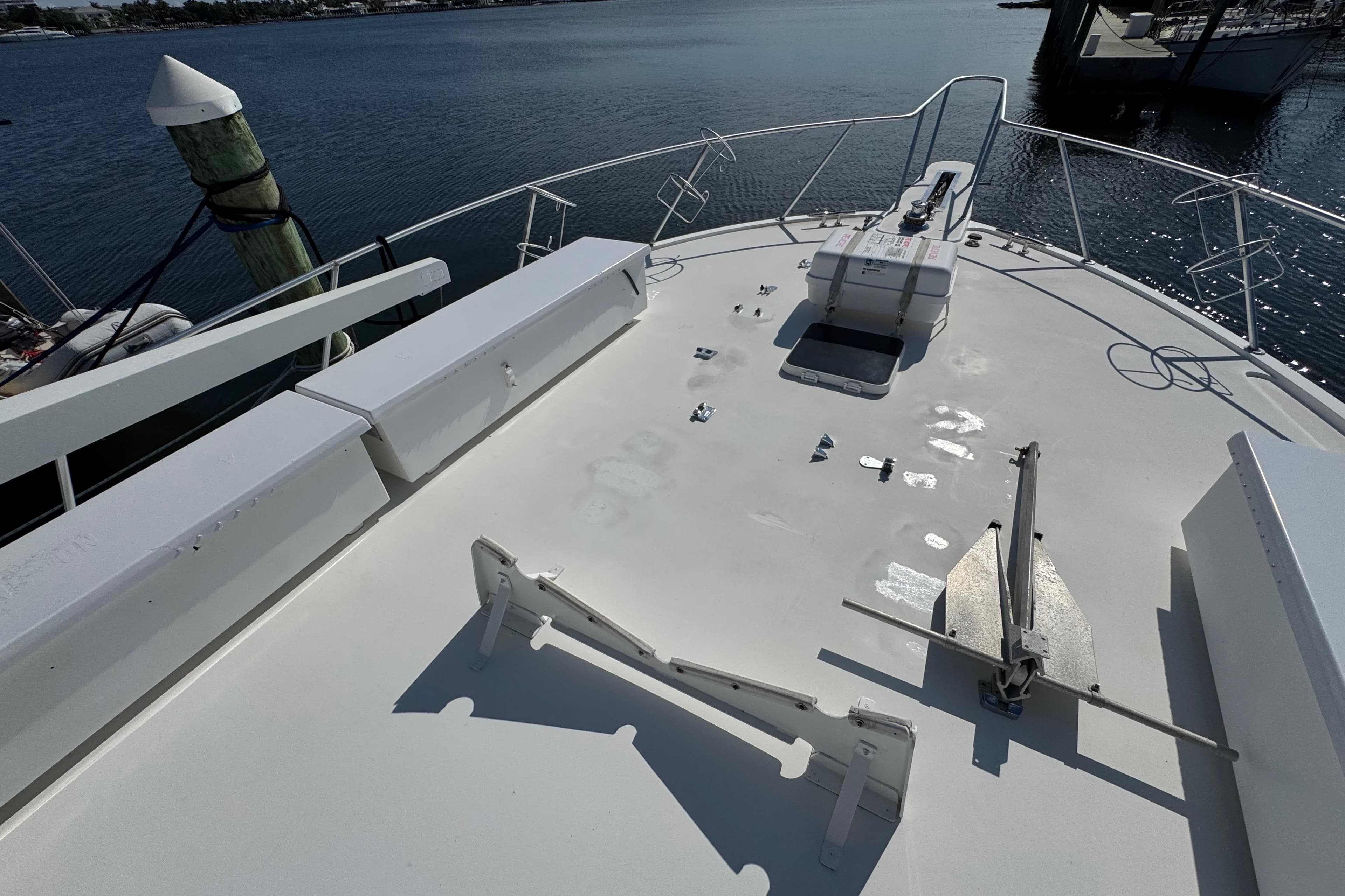Bow of 1995 Viking 58 Convertible yacht with anchor and railing, docked by the water.