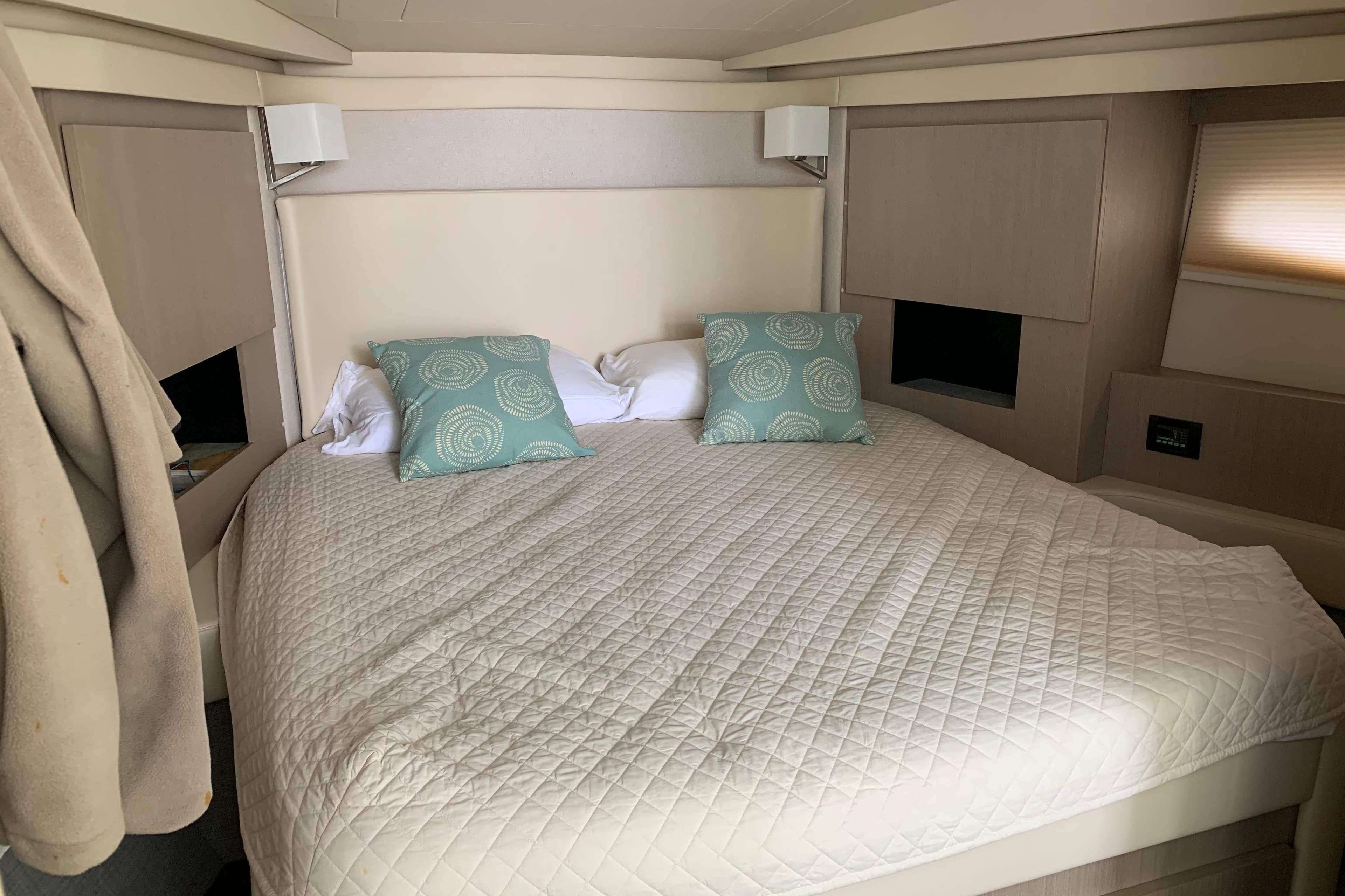 Luxurious bedroom interior of 2019 Regal 42 Grande Coupe yacht with cozy bedding.
