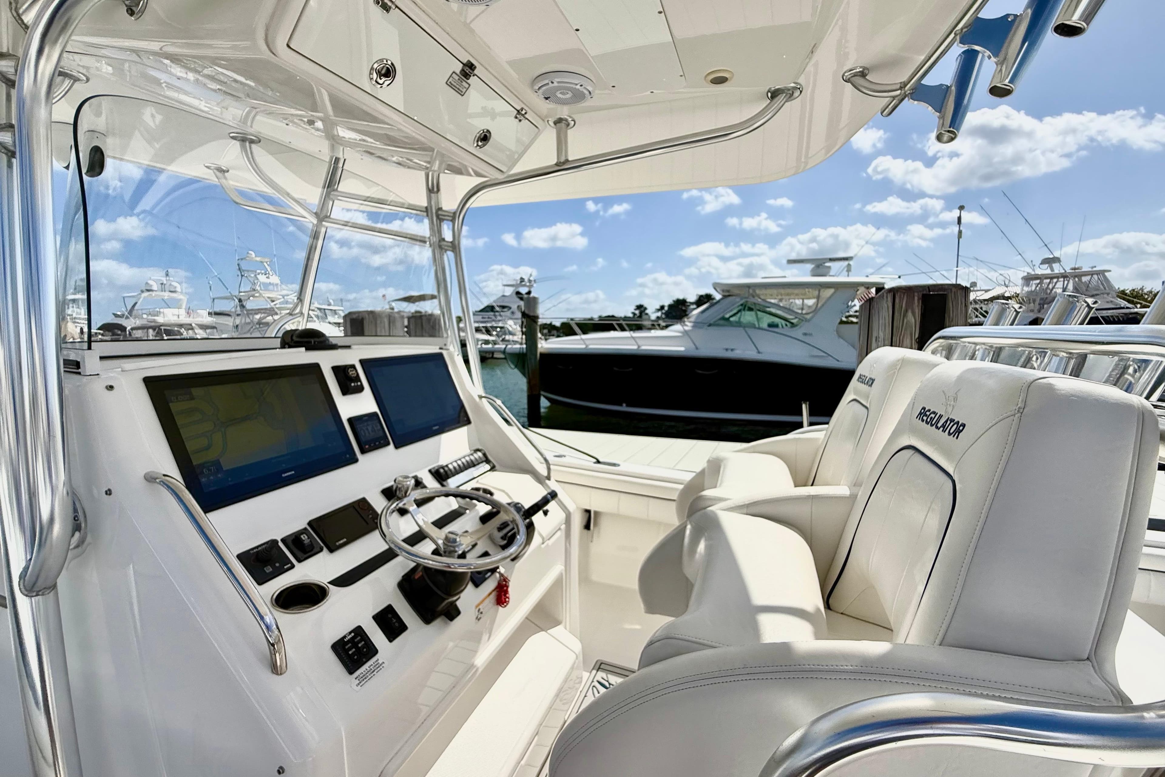 2016 Regulator 34SS boat cockpit with dual screens and plush seating at marina.