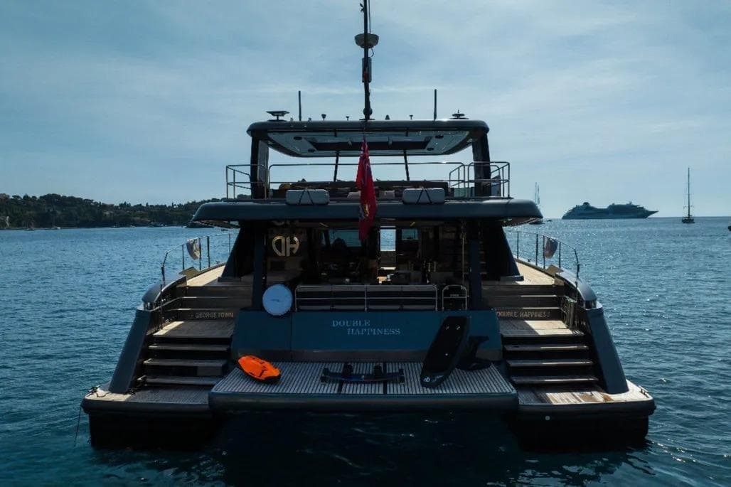 2024 Sunreef 60 Power Eco yacht on serene water, rear view with open deck.