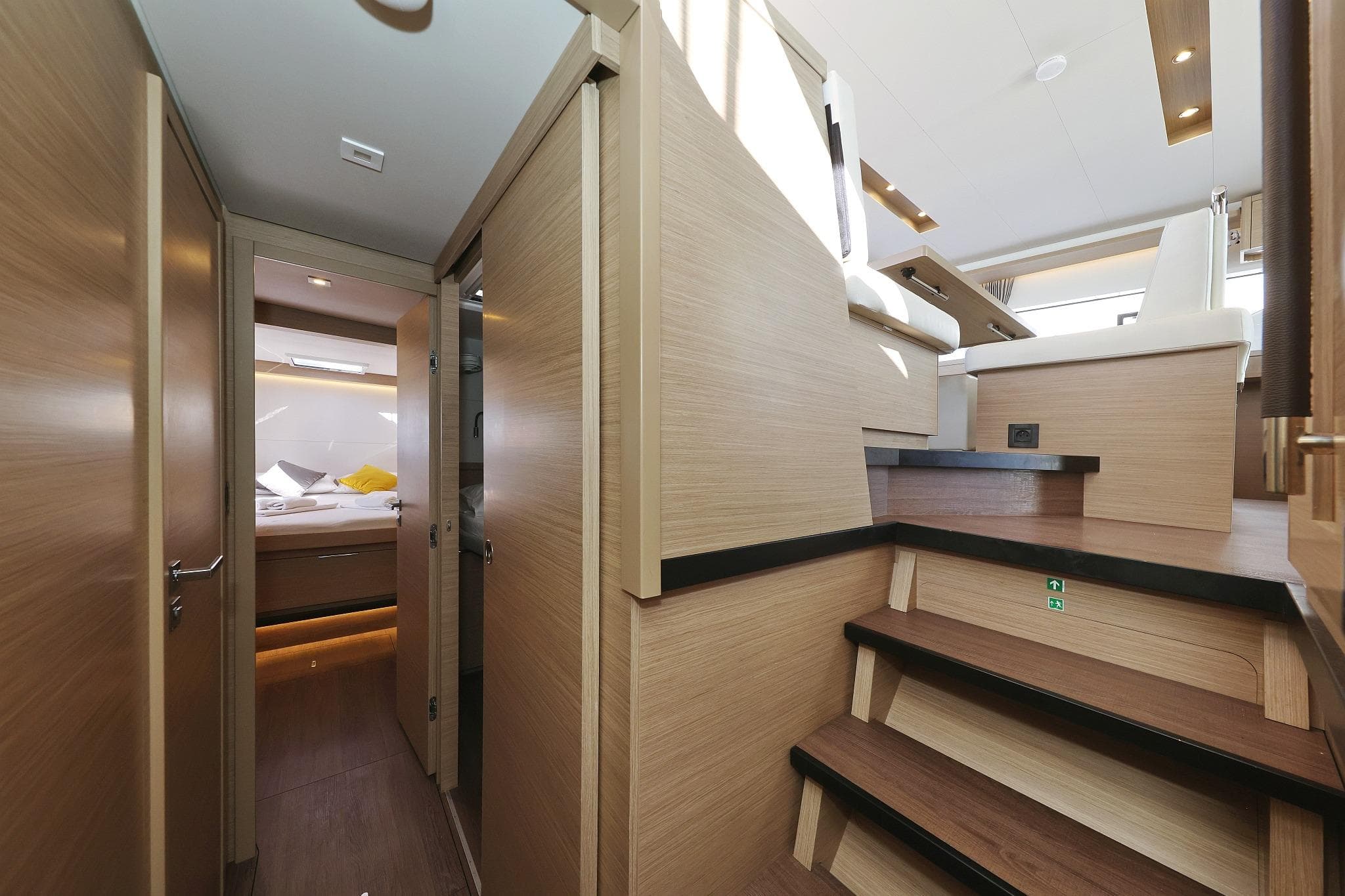 Luxurious interior of 2024 Lagoon 51 yacht, featuring modern wood finishes and cozy cabin space.