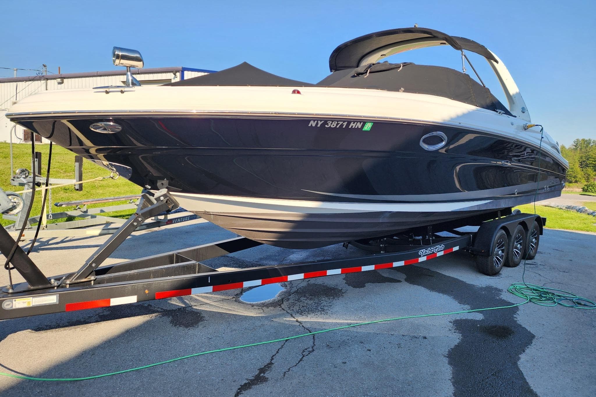 2019 Chaparral 297 SSX boat on trailer, parked outdoors in sunny setting.