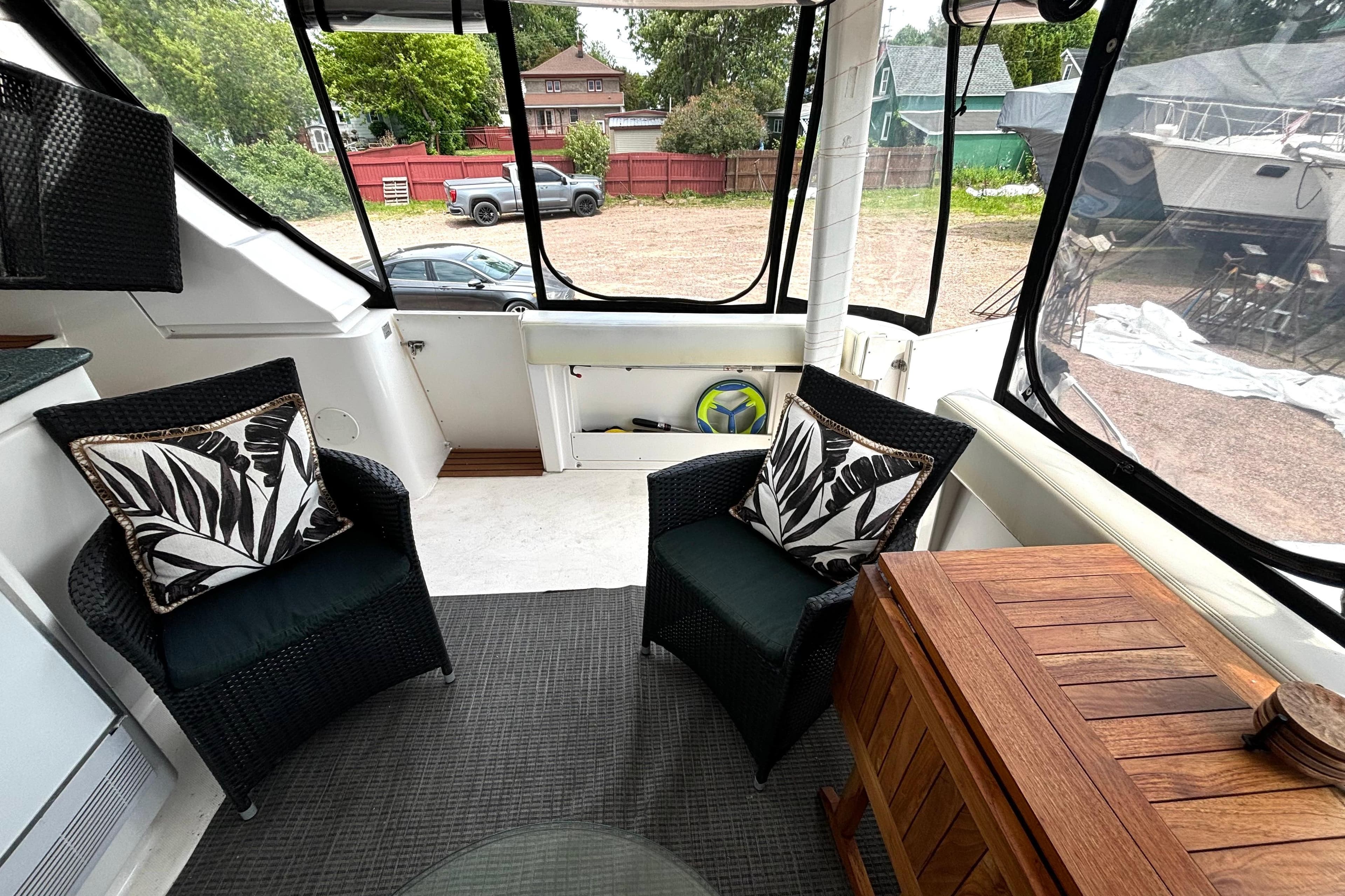 Interior of 1999 Silverton 453 Motor Yacht with wicker chairs and decorative pillows.