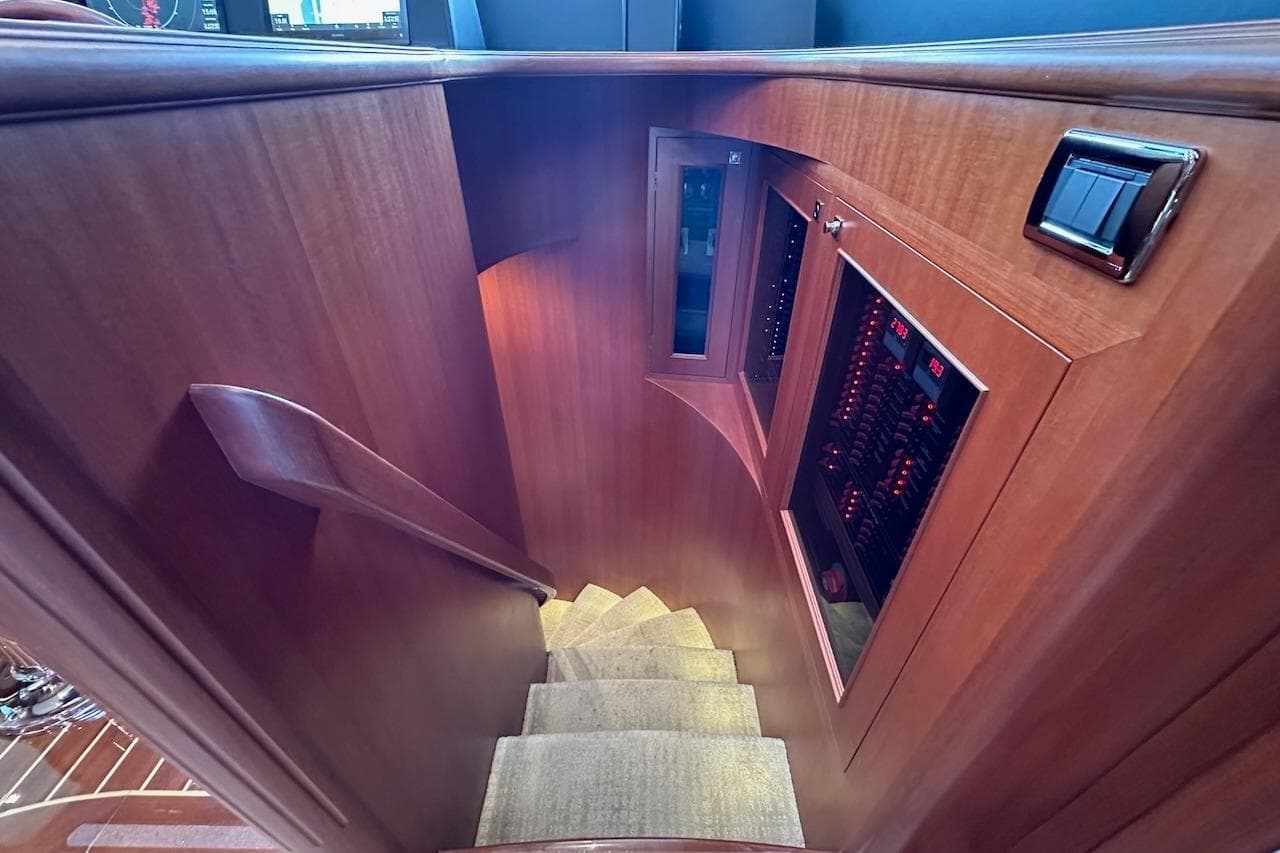 Staircase in 2024 Northwest 55 yacht with wooden paneling and control panels.