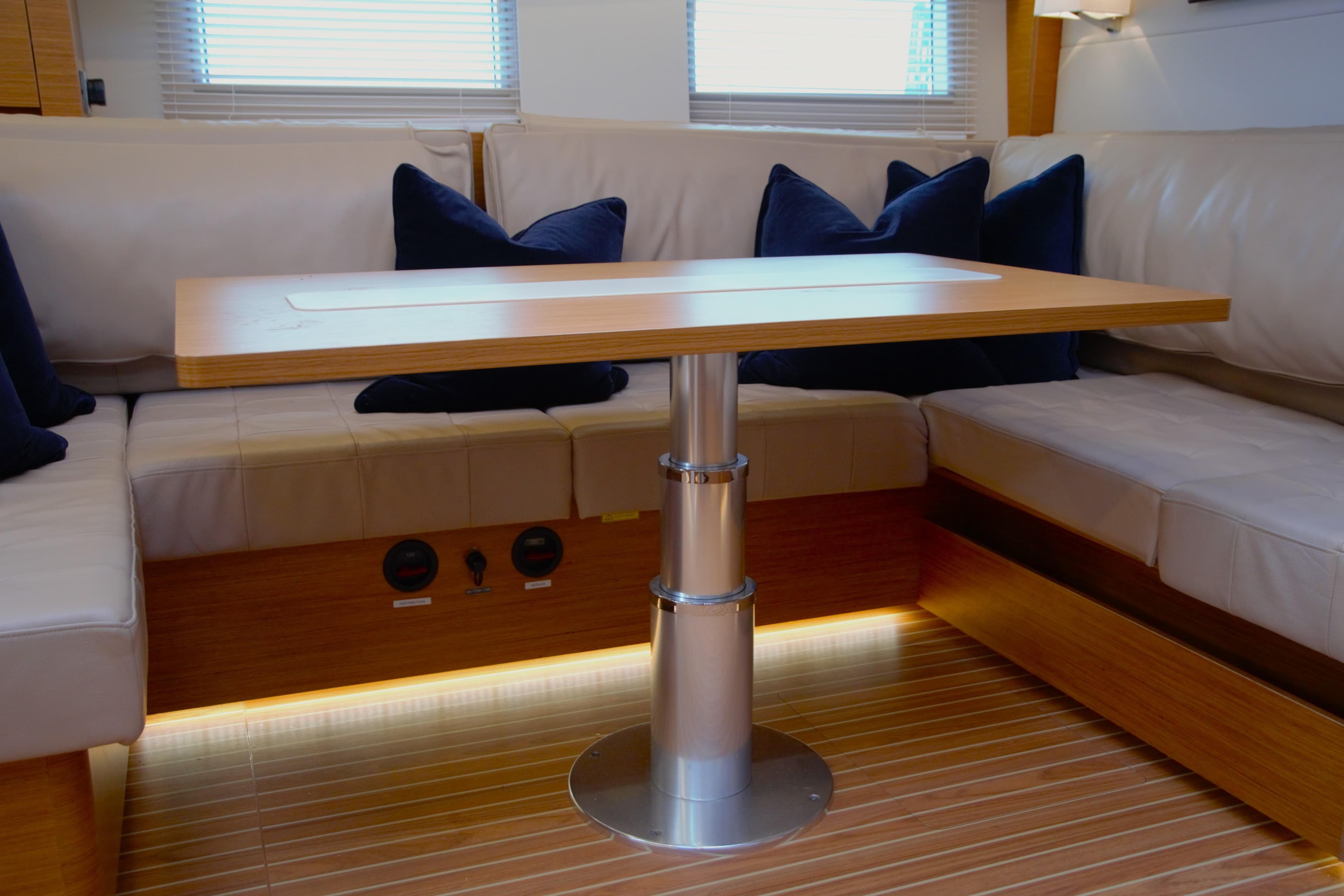 Interior of 2021 Hanse 588 yacht with modern seating and wooden table.