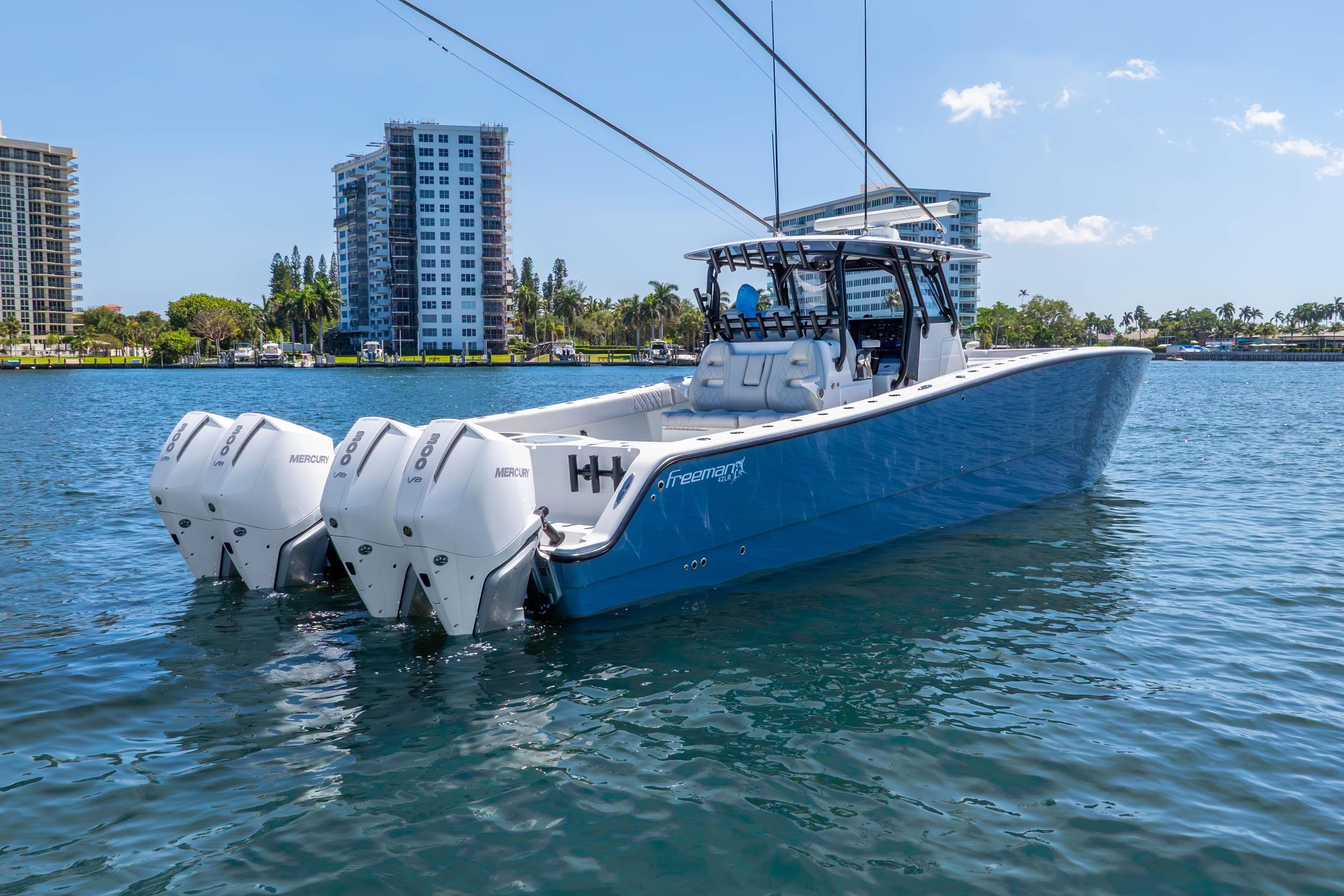 2019 Freeman 42LR boat with triple Mercury engines on a sunny waterfront.