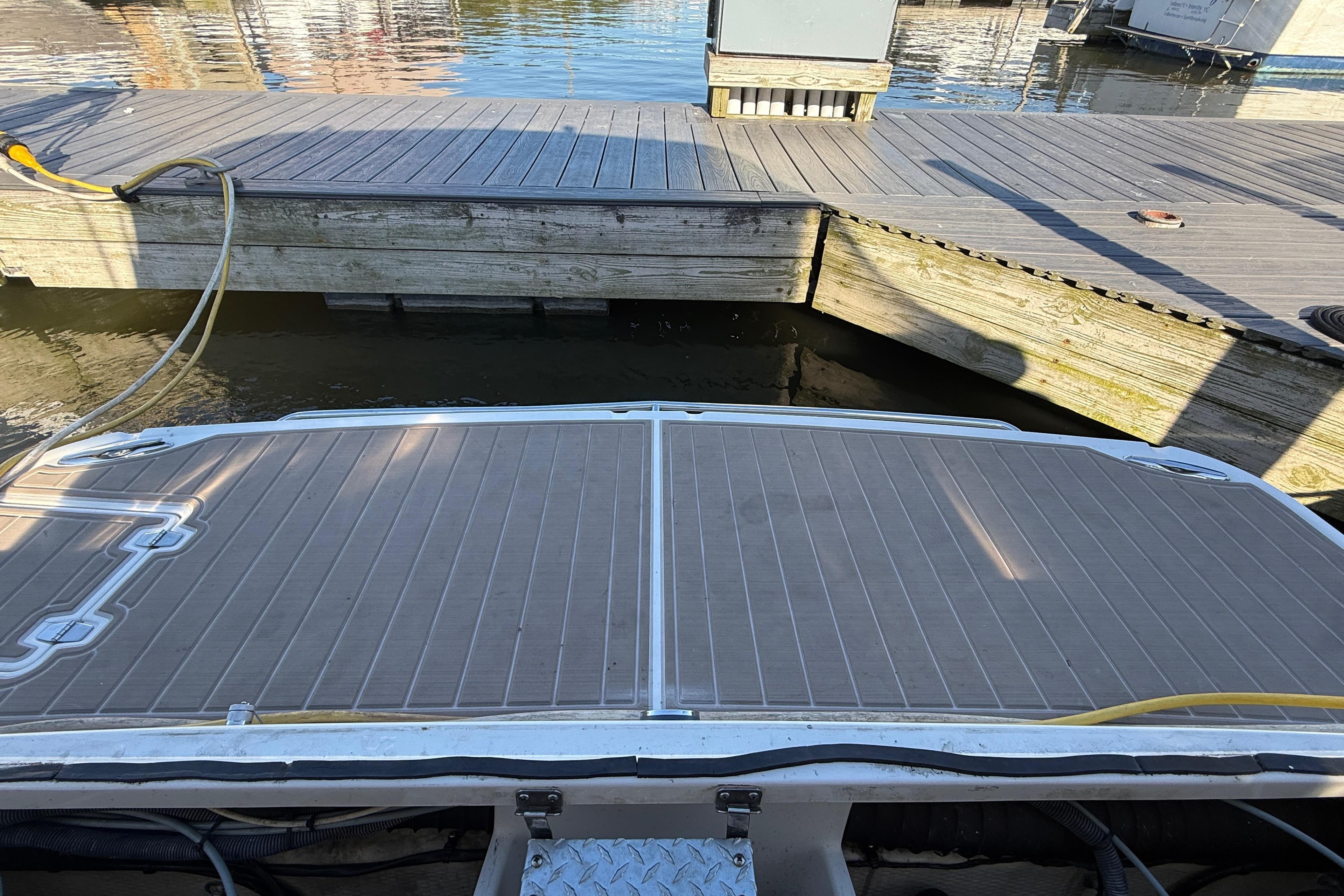 2005 Regal Commodore 3560 IO boat docked at a wooden pier with water reflections.