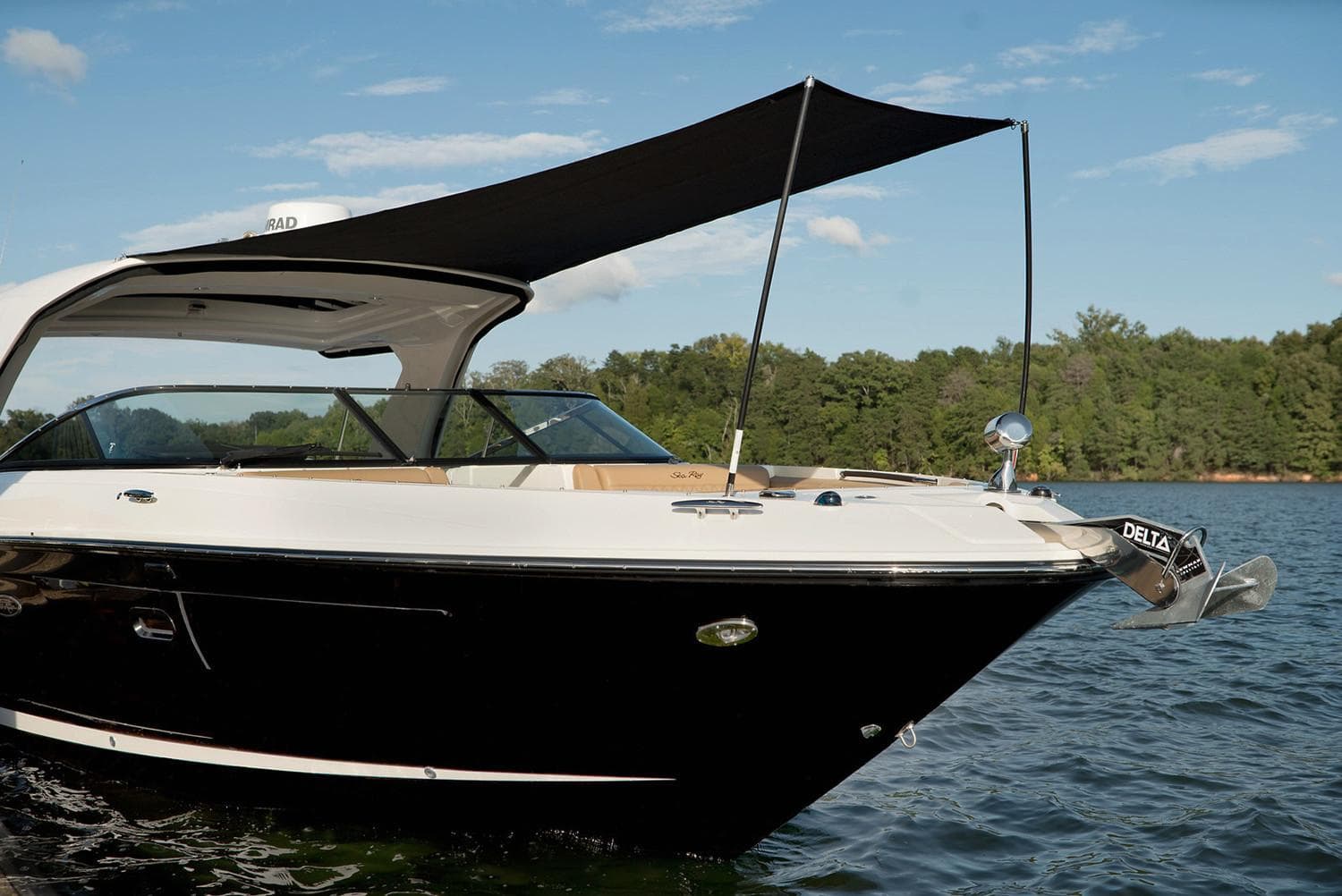Manufacturer Provided Image: 2020 Sea Ray SLX 350 boat on a lake with canopy, clear sky, and forested background.