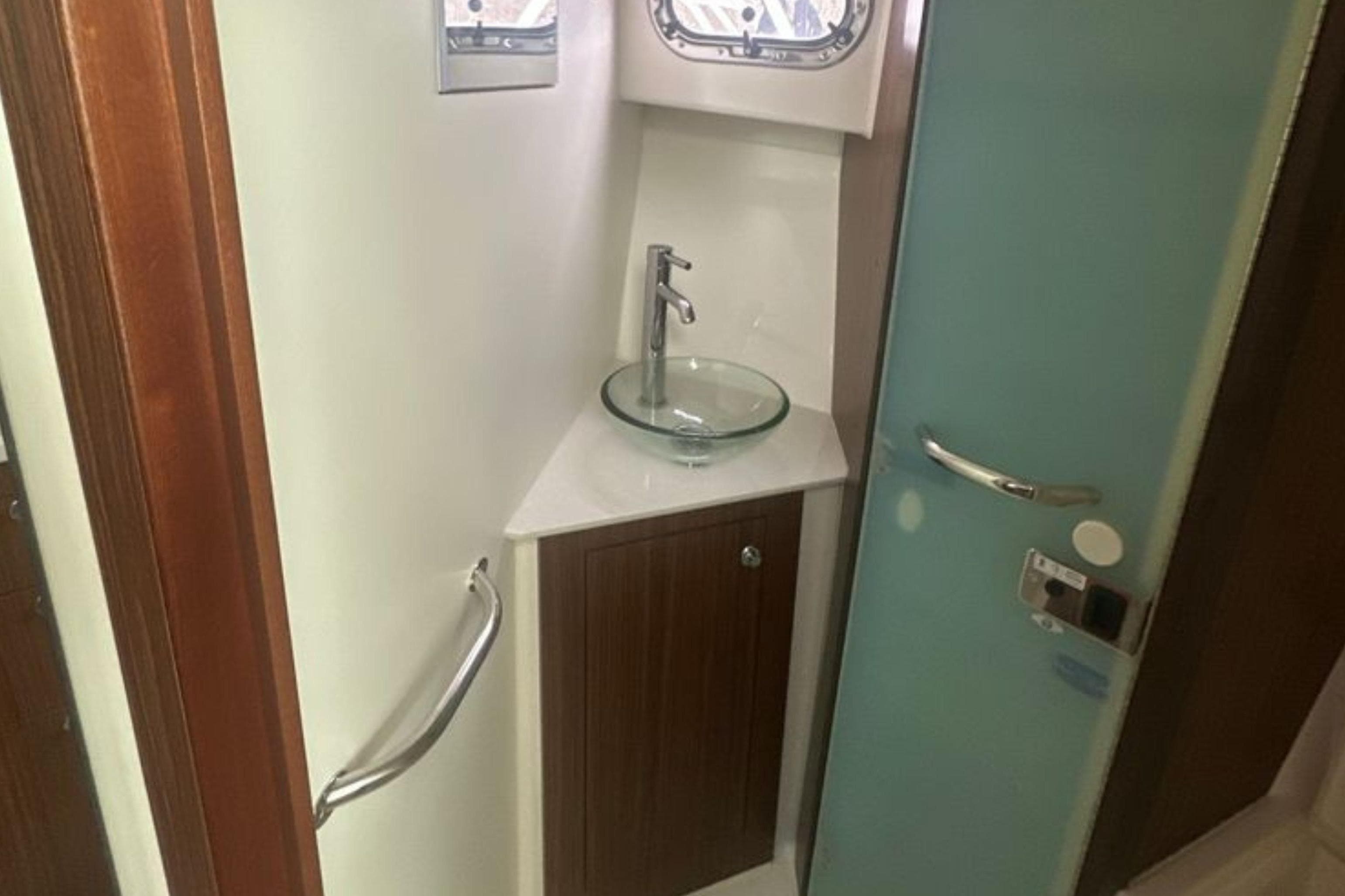 2017 Pursuit OS 355 Offshore bathroom with glass sink and modern fixtures.