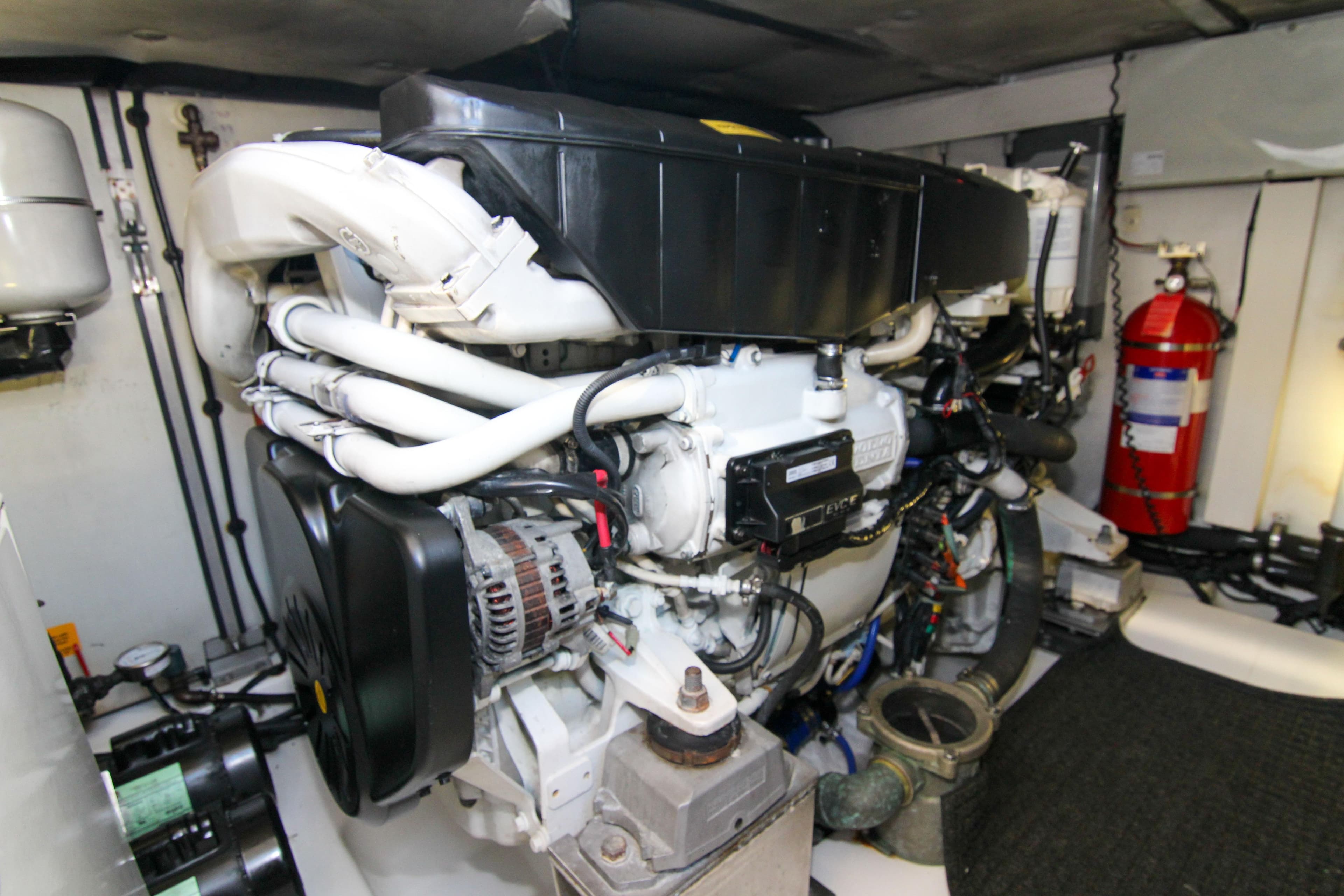 Engine room of 2016 Azimut 50 Flybridge yacht, featuring complex machinery and fire extinguisher.