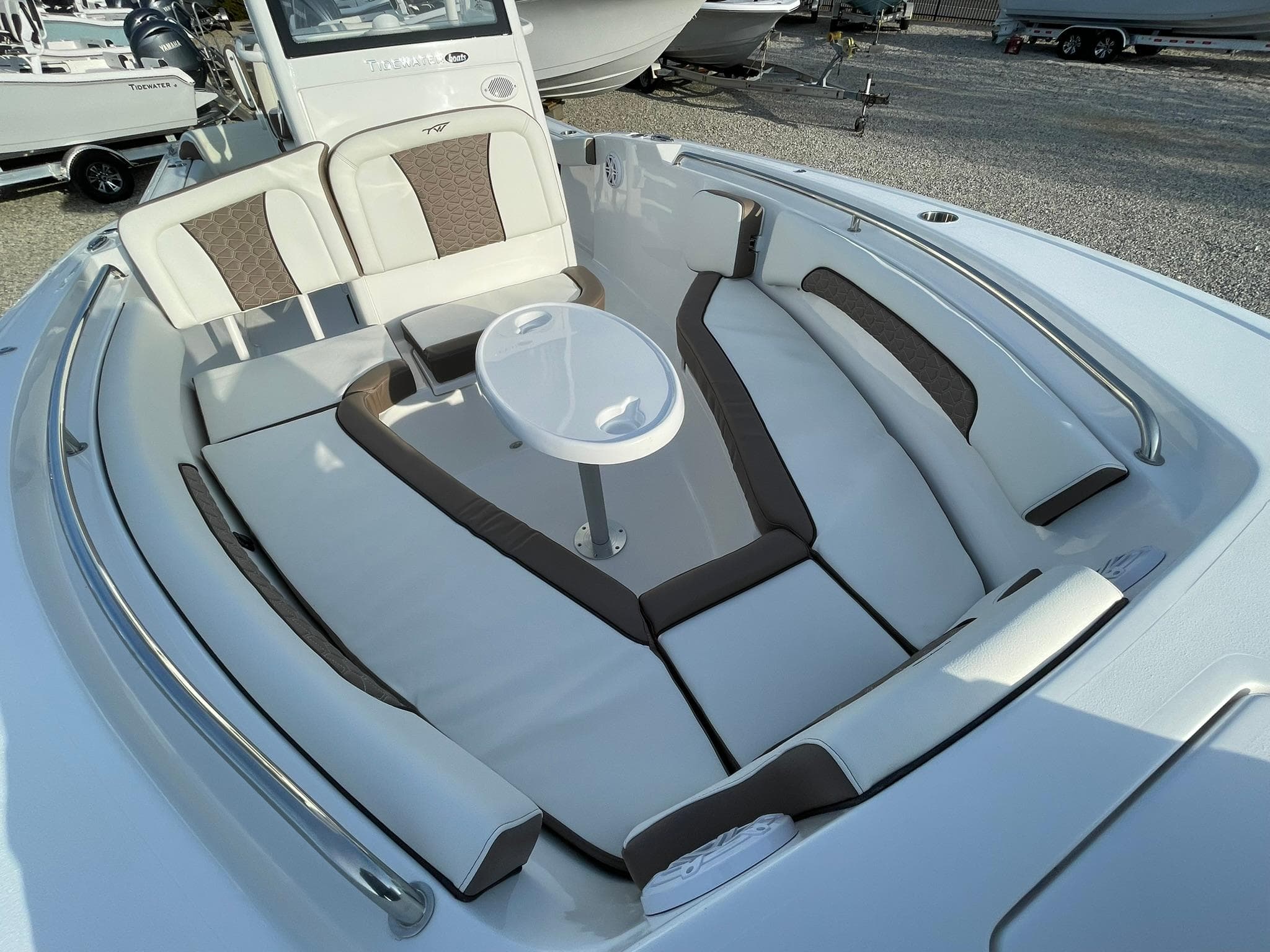 2025 Tidewater 232 SS boat interior with cushioned seating and a central table.