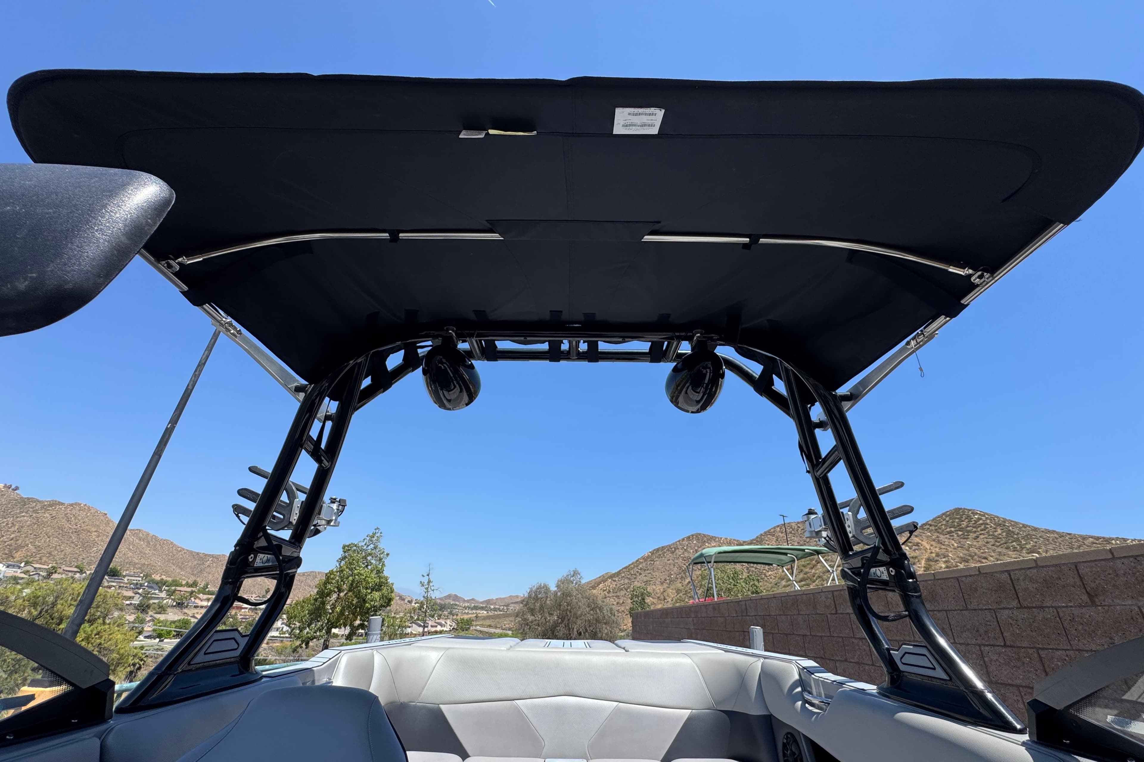 2022 Moomba Max boat interior with canopy, speakers, and scenic mountain backdrop.