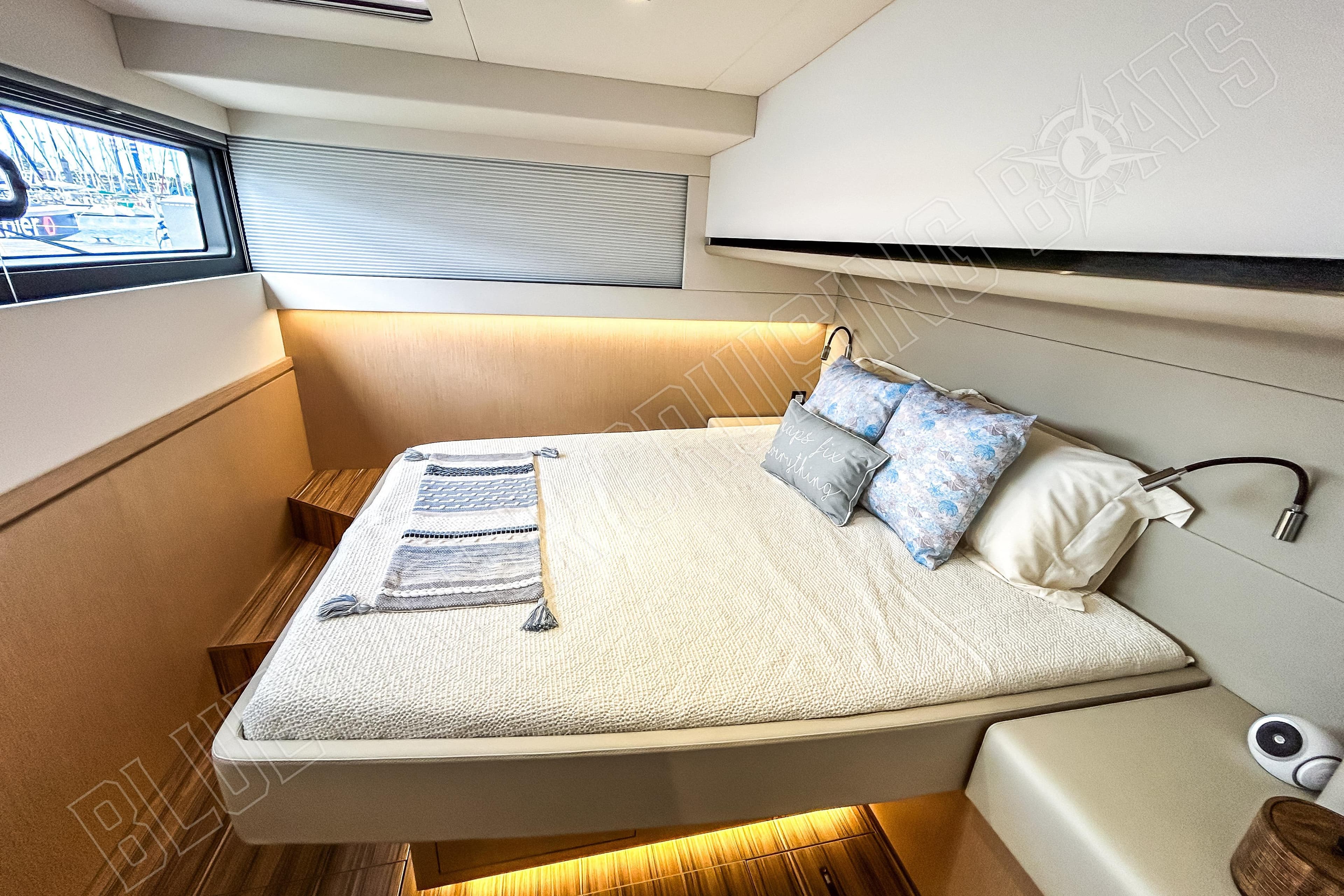 Luxurious cabin interior of 2025 Privilege 580 yacht with cozy bedding and modern design.