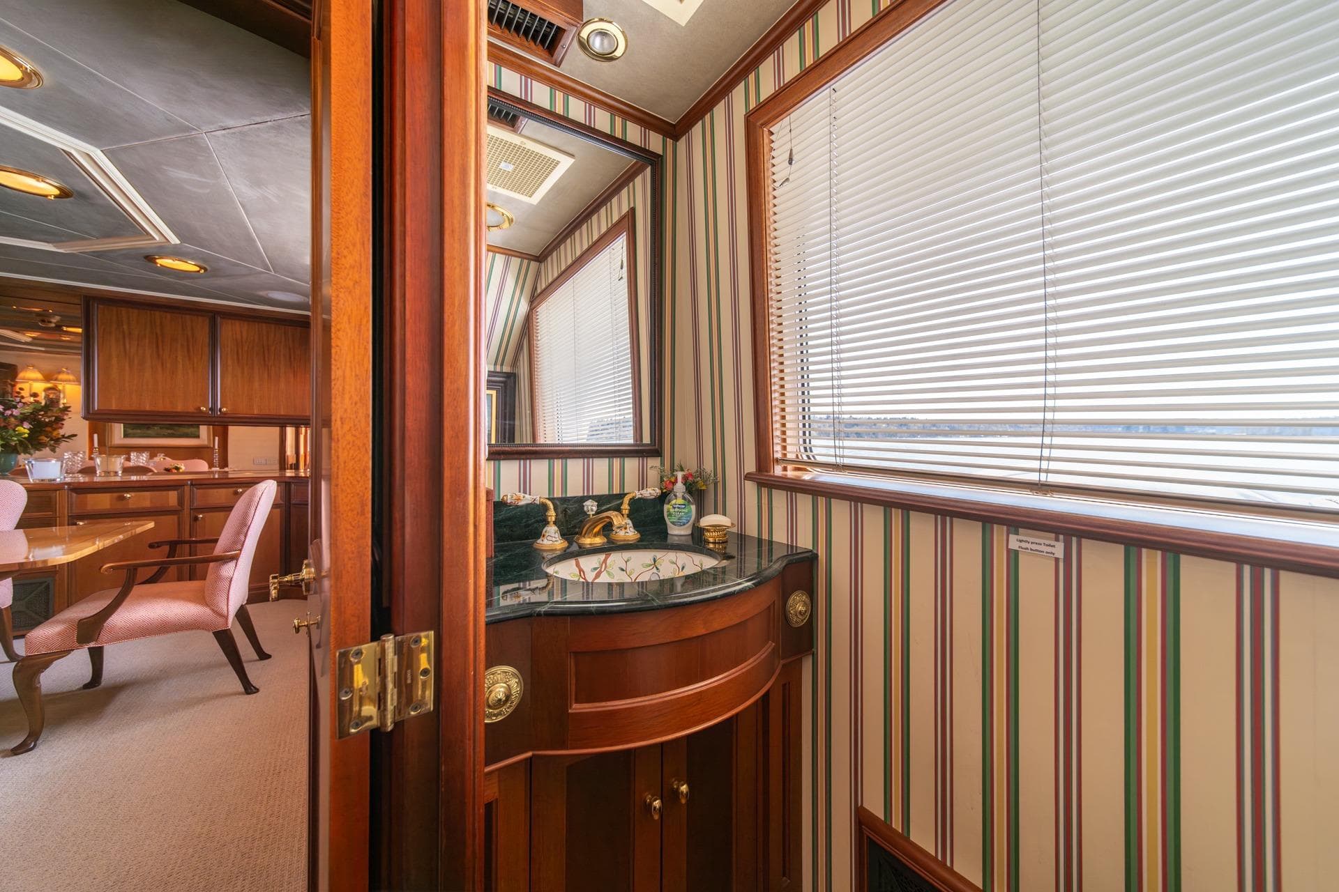 Luxurious interior of 1997 Trident Tri-Deck Motor Yacht with elegant wood and striped decor.