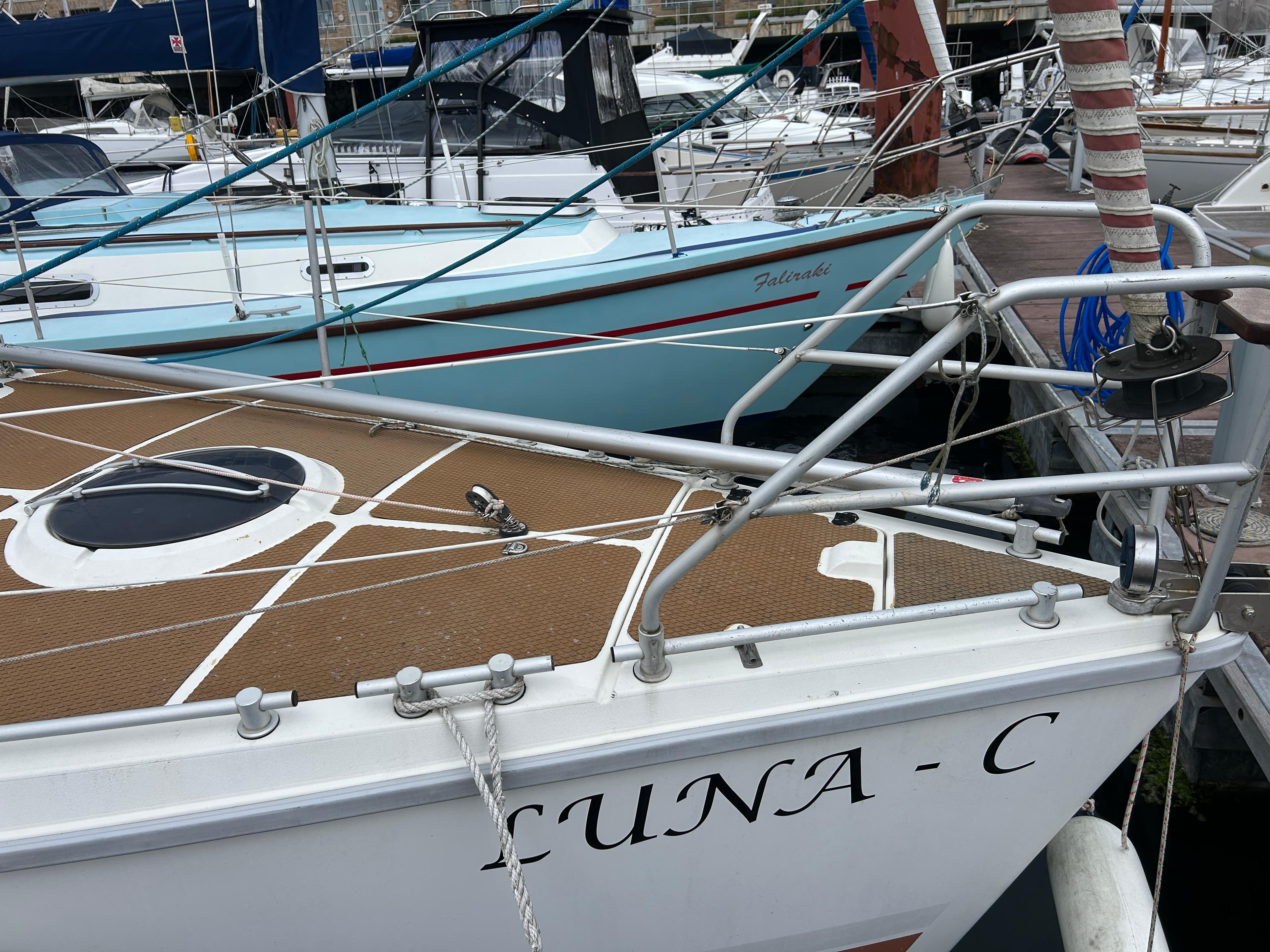 1991 Etap 28i sailboat "LUNA-C" docked at marina, showing deck and railing.