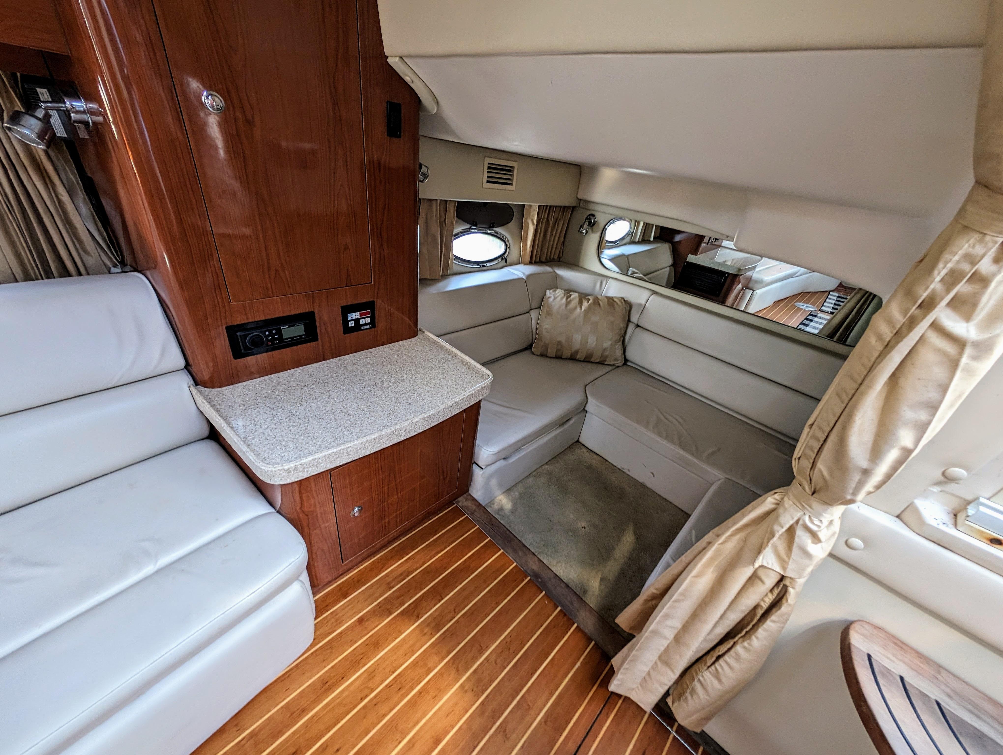 Interior of a 2005 Regal 3560 yacht with wood flooring and beige seating.