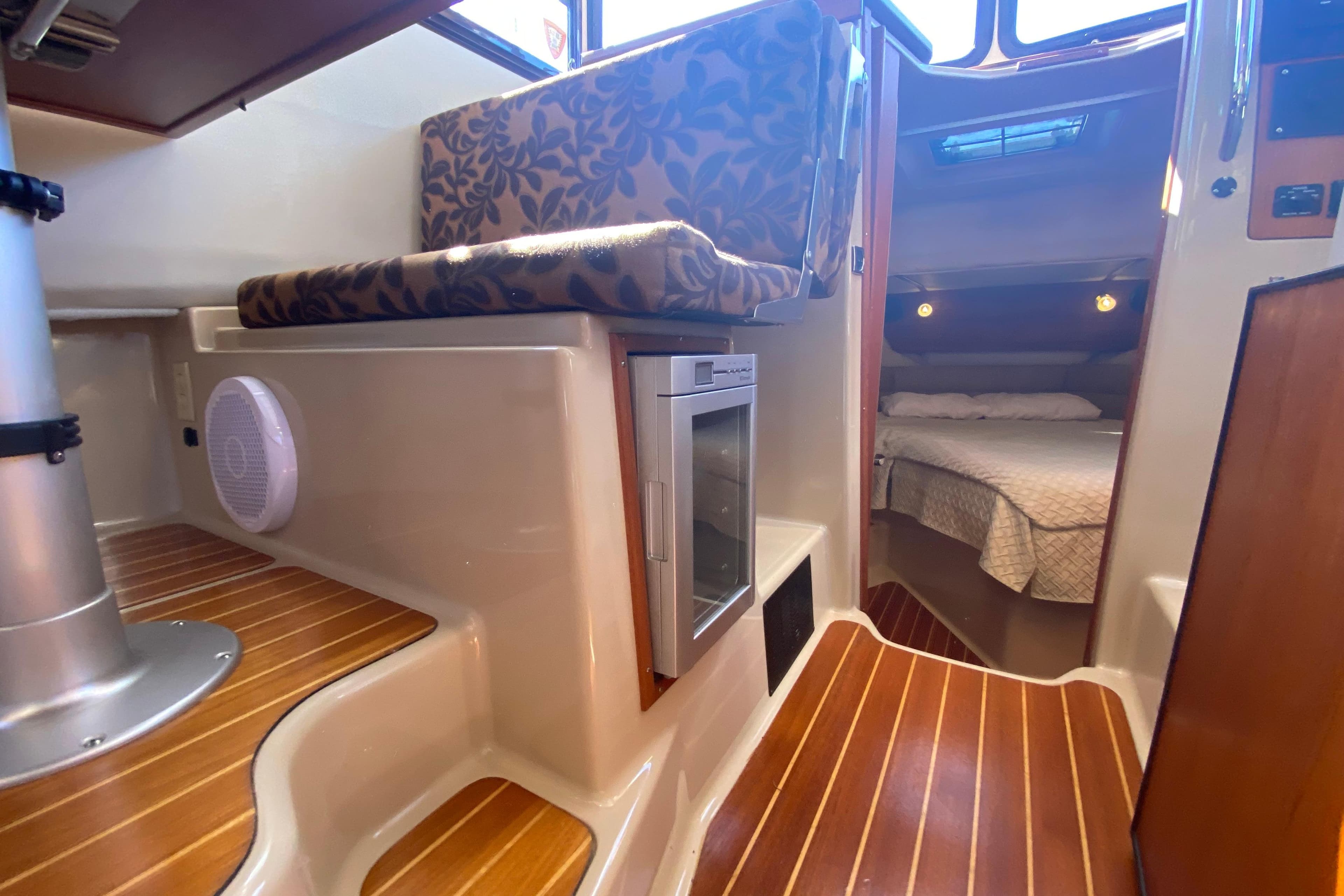 2010 Ranger Tugs R-29 interior with wood flooring, seating, and cozy sleeping area.