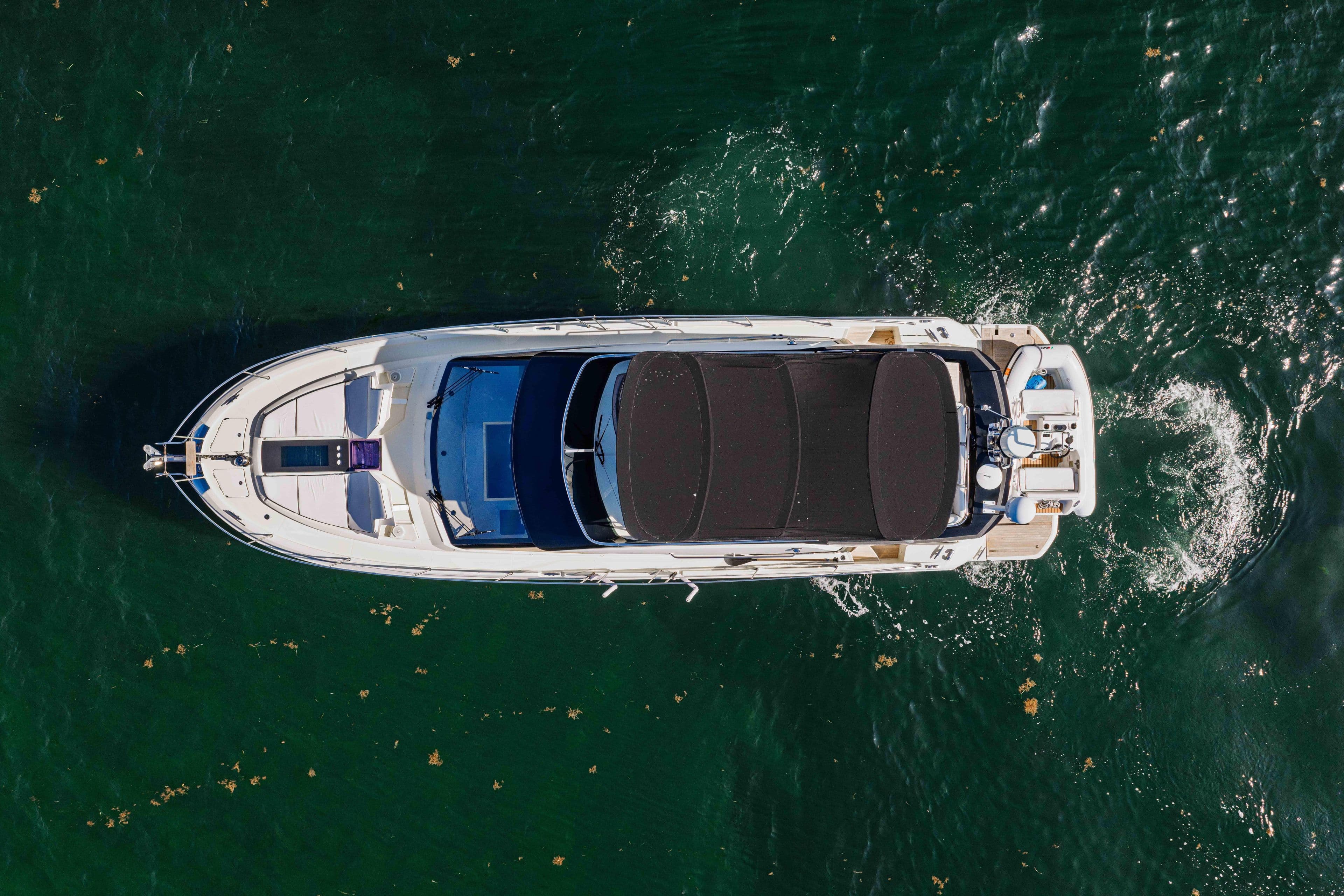 Aerial view of 2017 Monte Carlo Yachts MC5 cruising on green water.