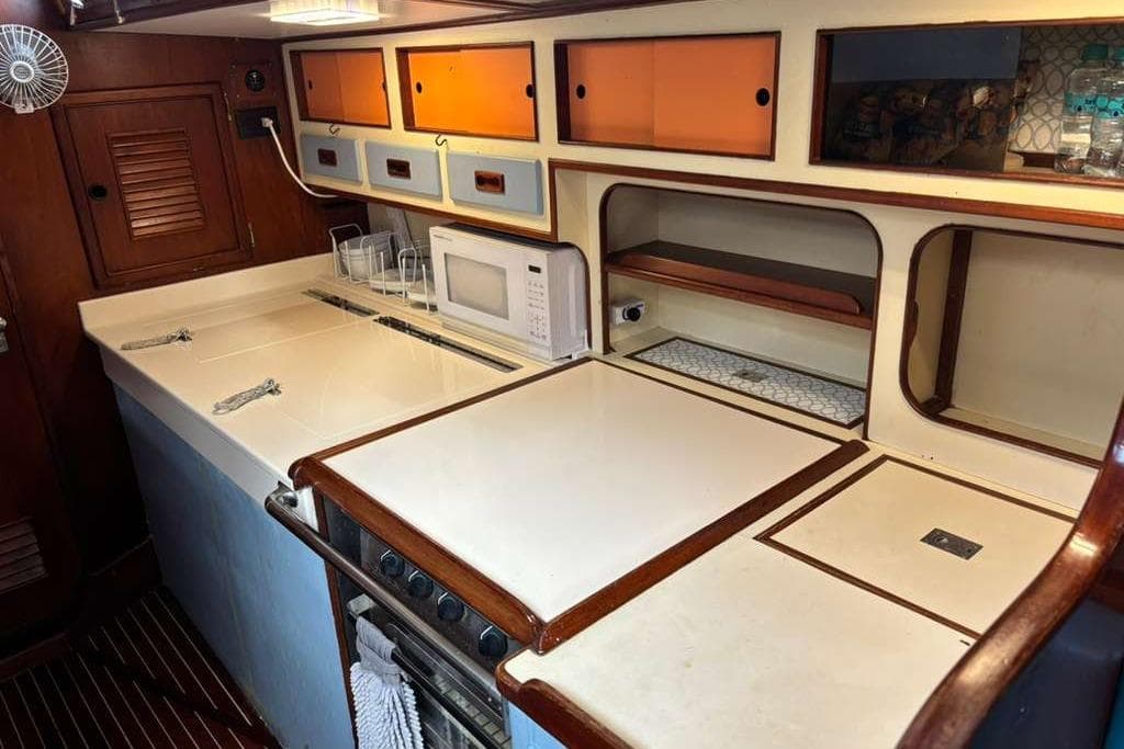 Galley kitchen in 1982 Steven Custom Stevens 47 yacht with microwave and storage cabinets.