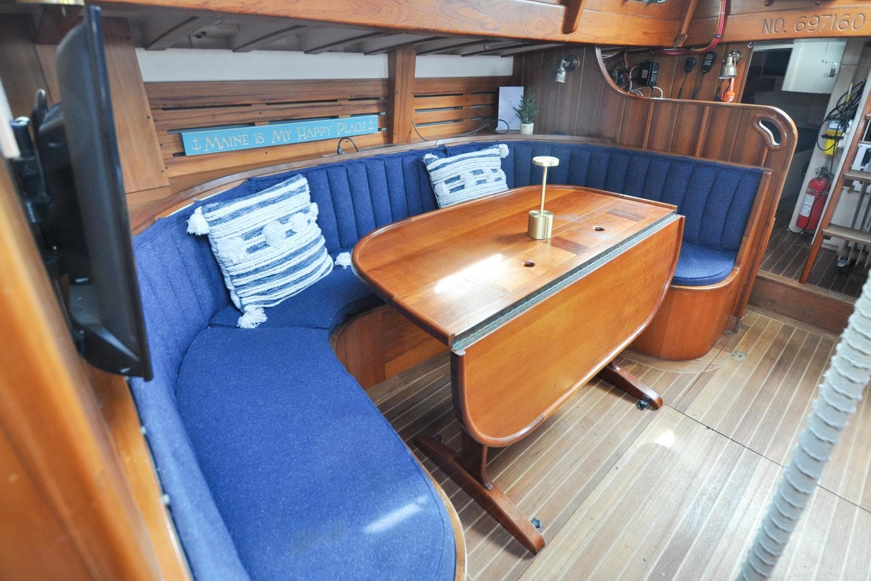 Cozy 1987 Custom Wittholtz/Luzier Sloop/Cutter interior with blue seating and wooden table.