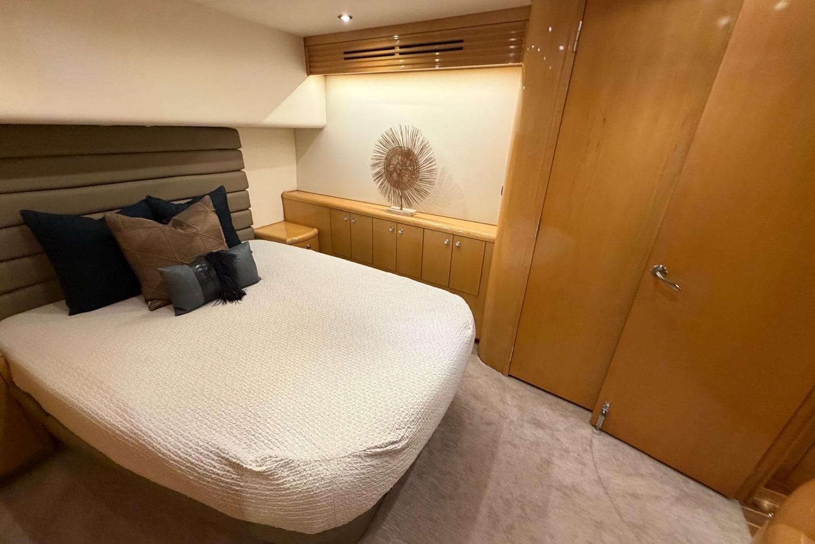 Luxurious bedroom interior of 2003 Hatteras 54 Convertible yacht with elegant decor.
