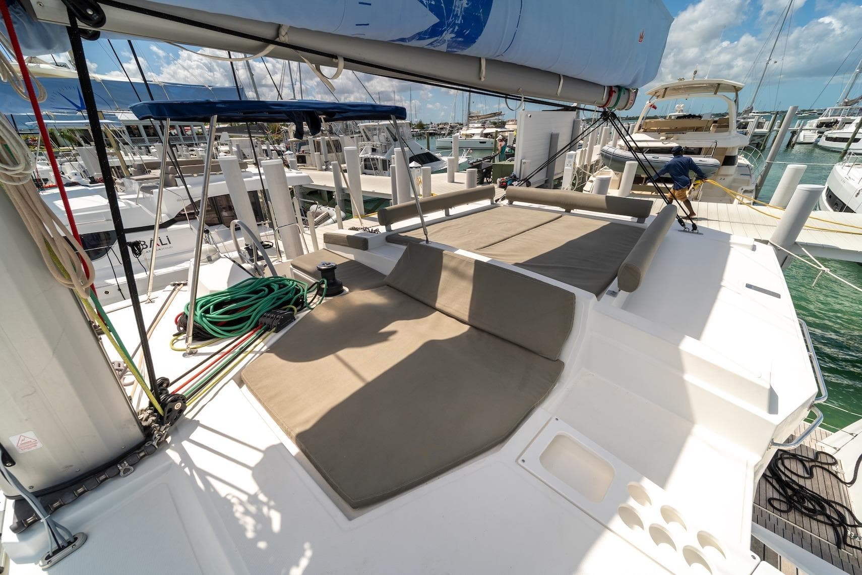 2022 Bali 4.2 yacht deck with seating, docked at marina under blue sky.