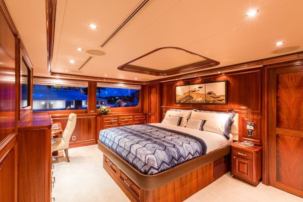 Luxurious bedroom interior of 2008 Westport 130 yacht, featuring elegant wood paneling and ambient lighting.