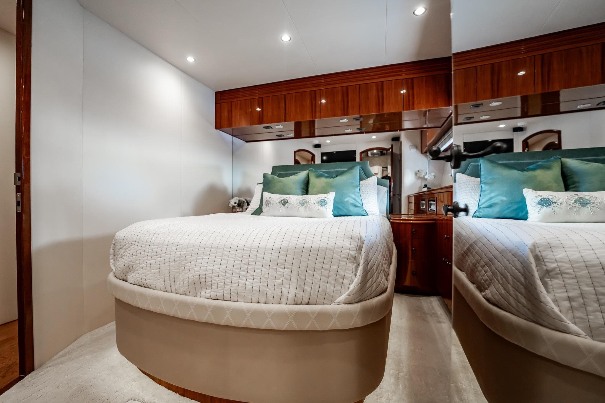 Luxurious bedroom interior of 2012 Hatteras 80 Motor Yacht with elegant bedding and wood accents.
