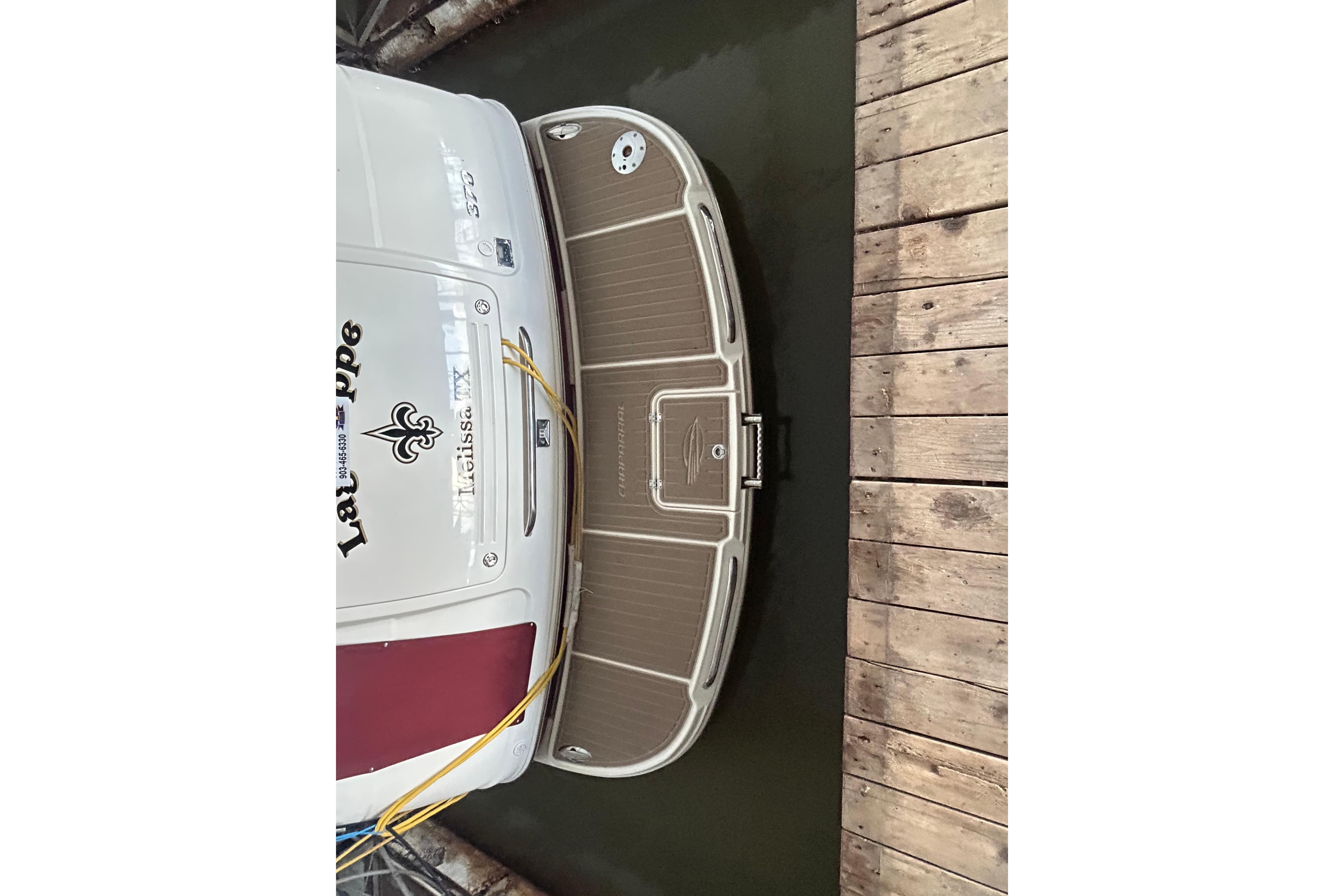 2010 Chaparral Signature 370 docked, showing rear deck and wooden pier.