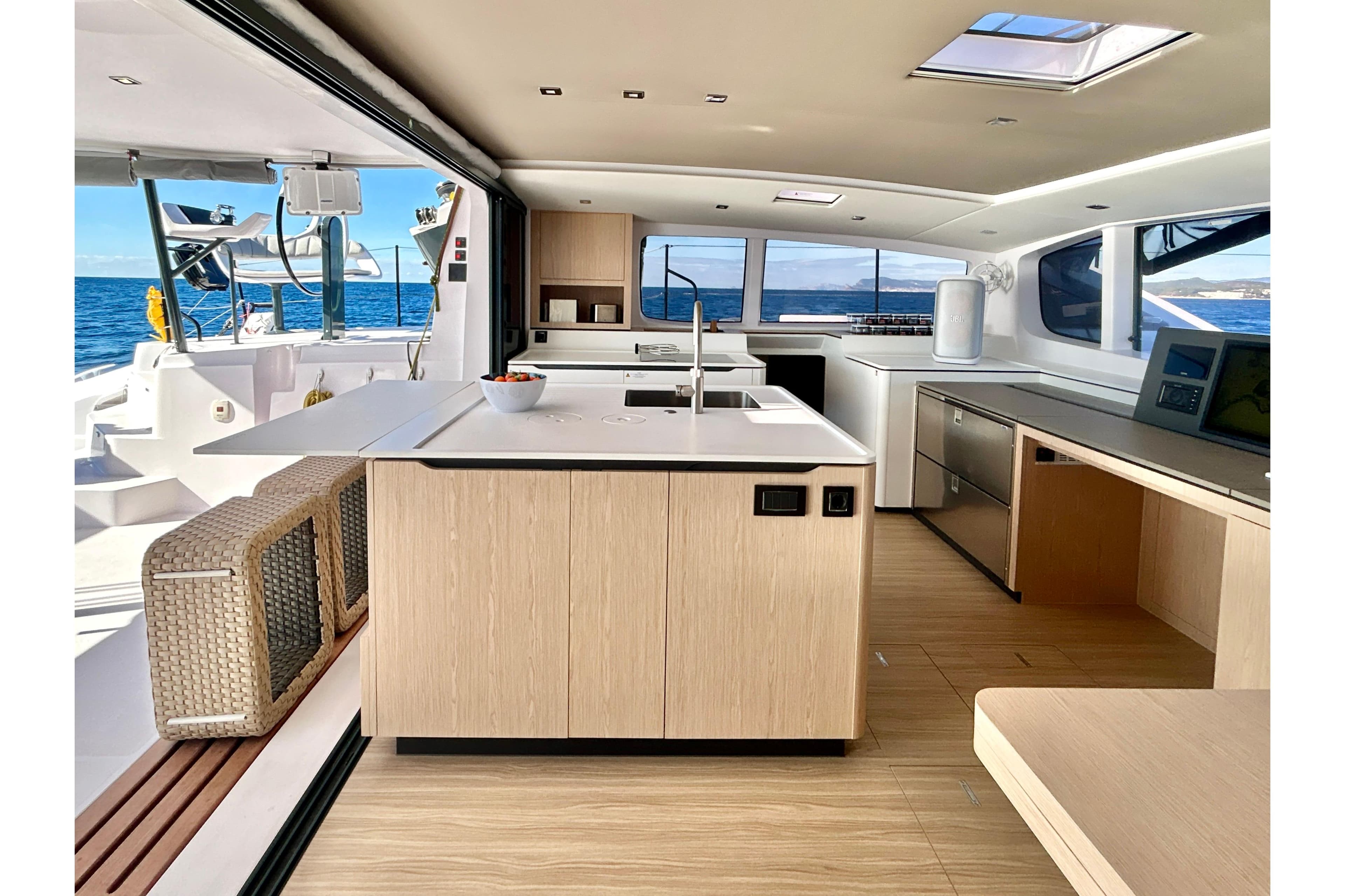 Luxurious interior of 2025 Outremer 55 yacht with modern kitchen and ocean view.