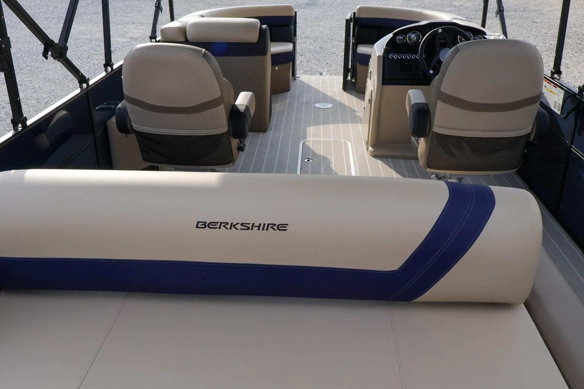 2024 Berkshire 24UL CTS pontoon boat interior with beige seating and steering console.