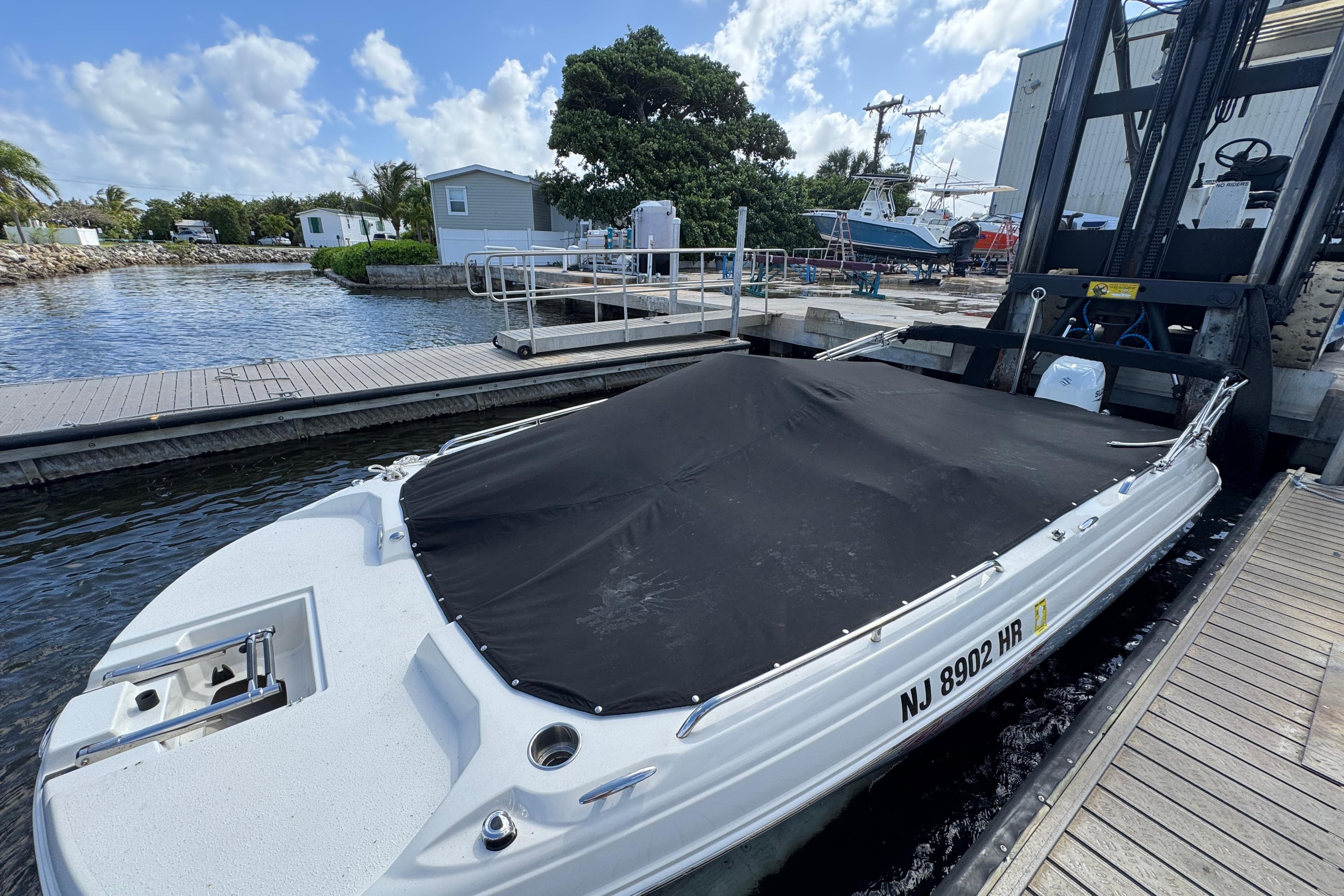 2022 Stingray 192 SC boat docked with cover, surrounded by marina scenery.