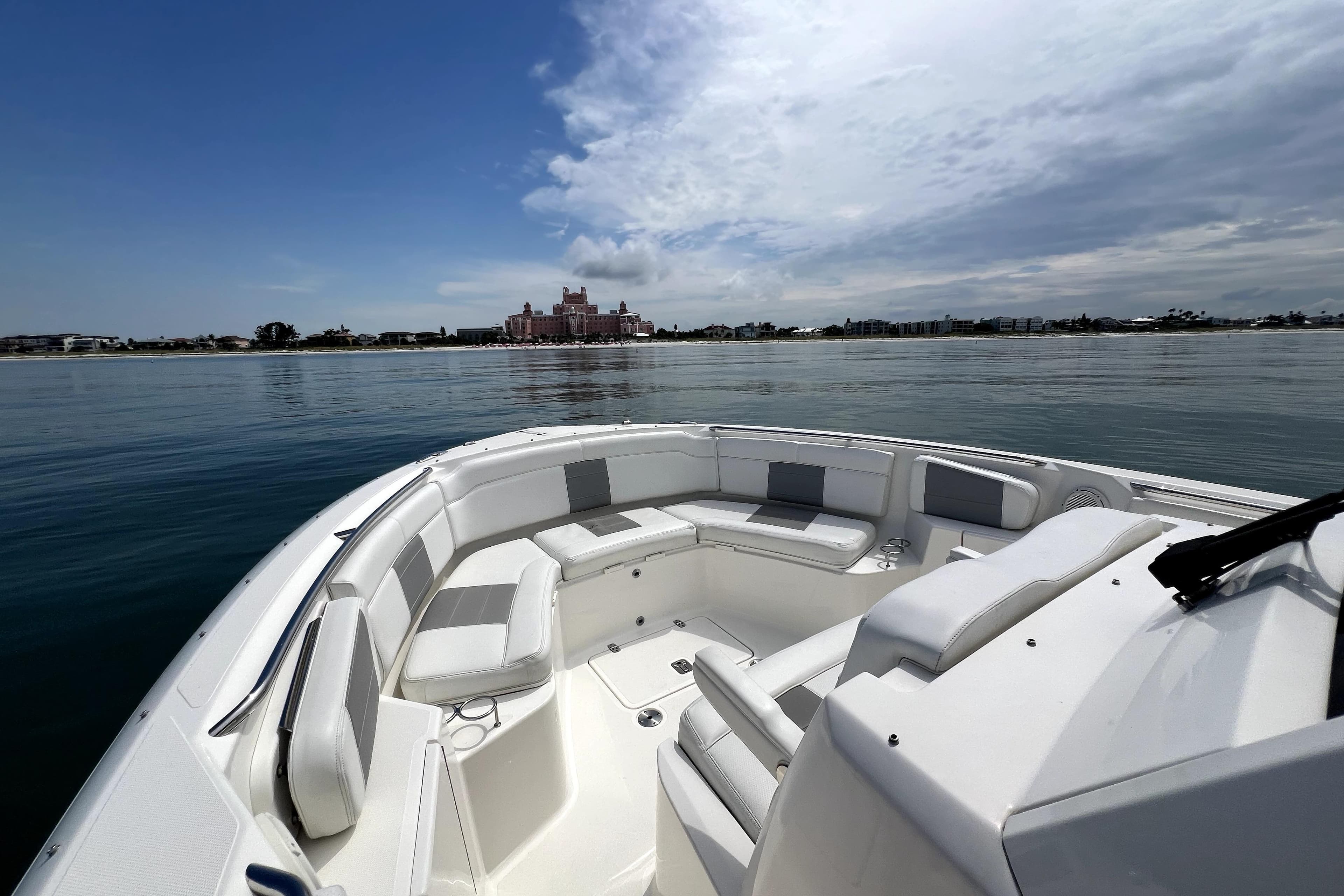 2020 Pursuit S 328 Sport boat on calm water with scenic coastal view.