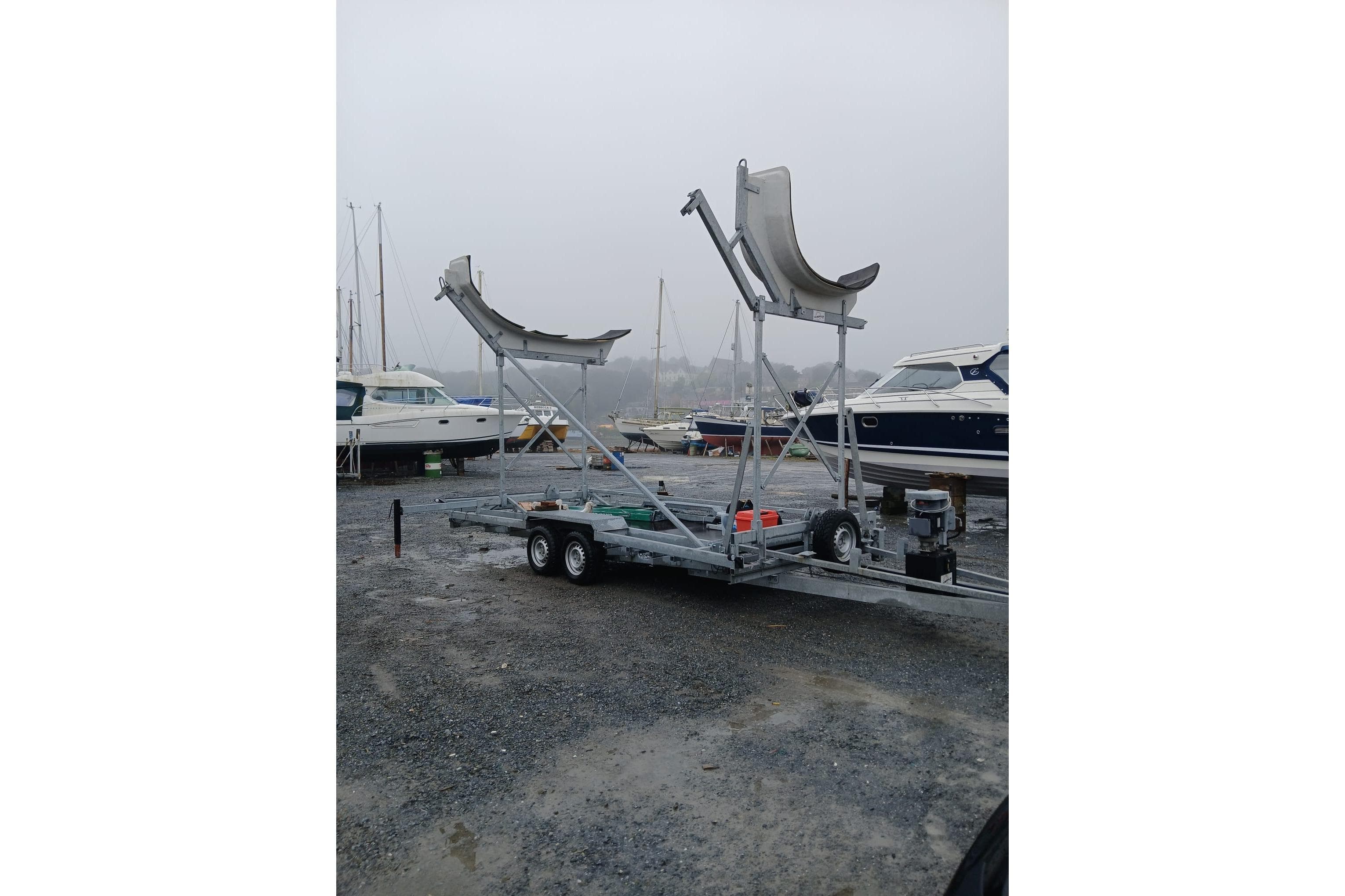 Boat trailer for One Design Cape 31, 2022 model, in a marina setting.
