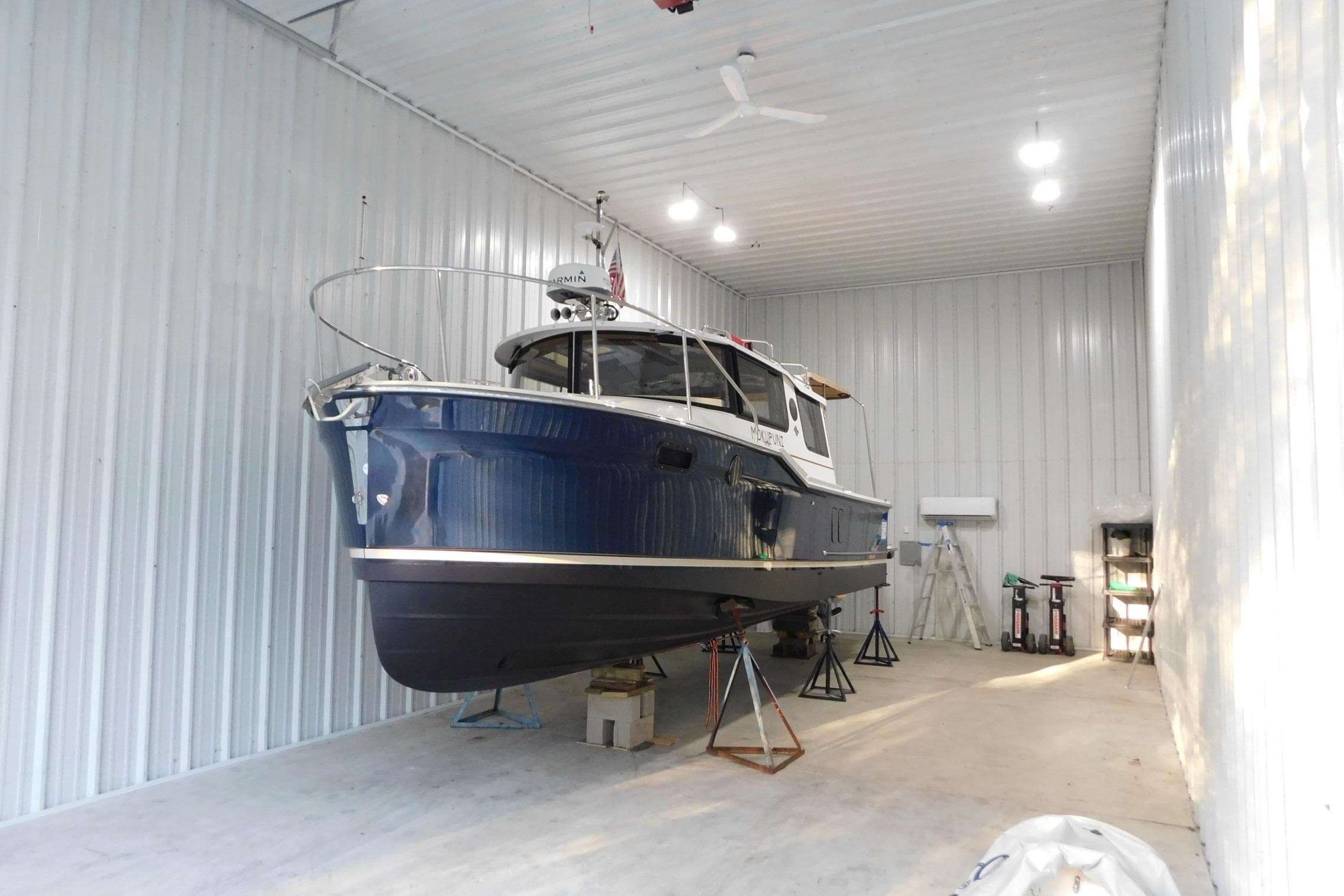 2022 Ranger Tugs R-27 boat in storage, blue hull, indoor facility.