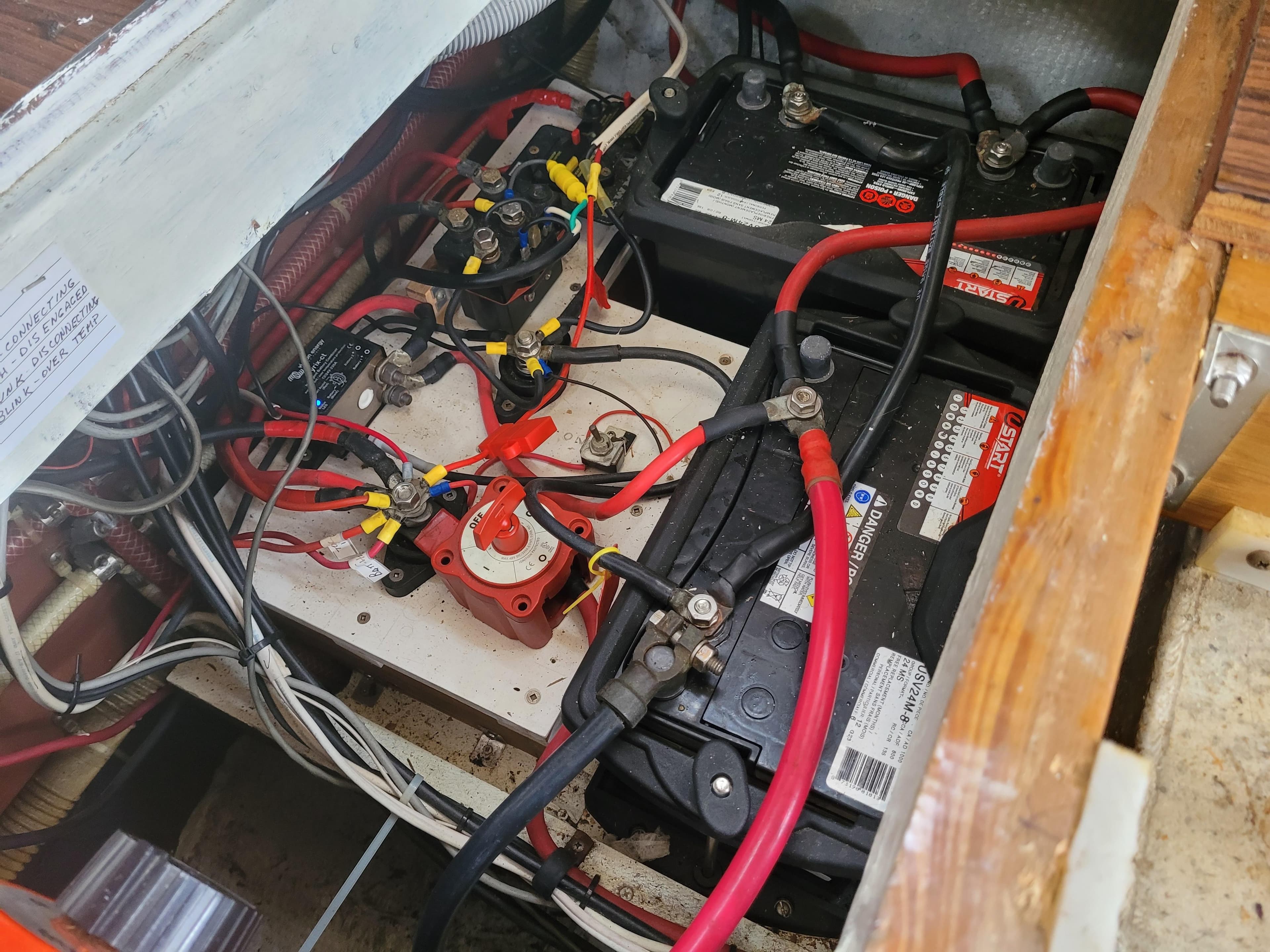 Battery compartment of a 1981 Mainship 34 Trawler with wiring and connections.