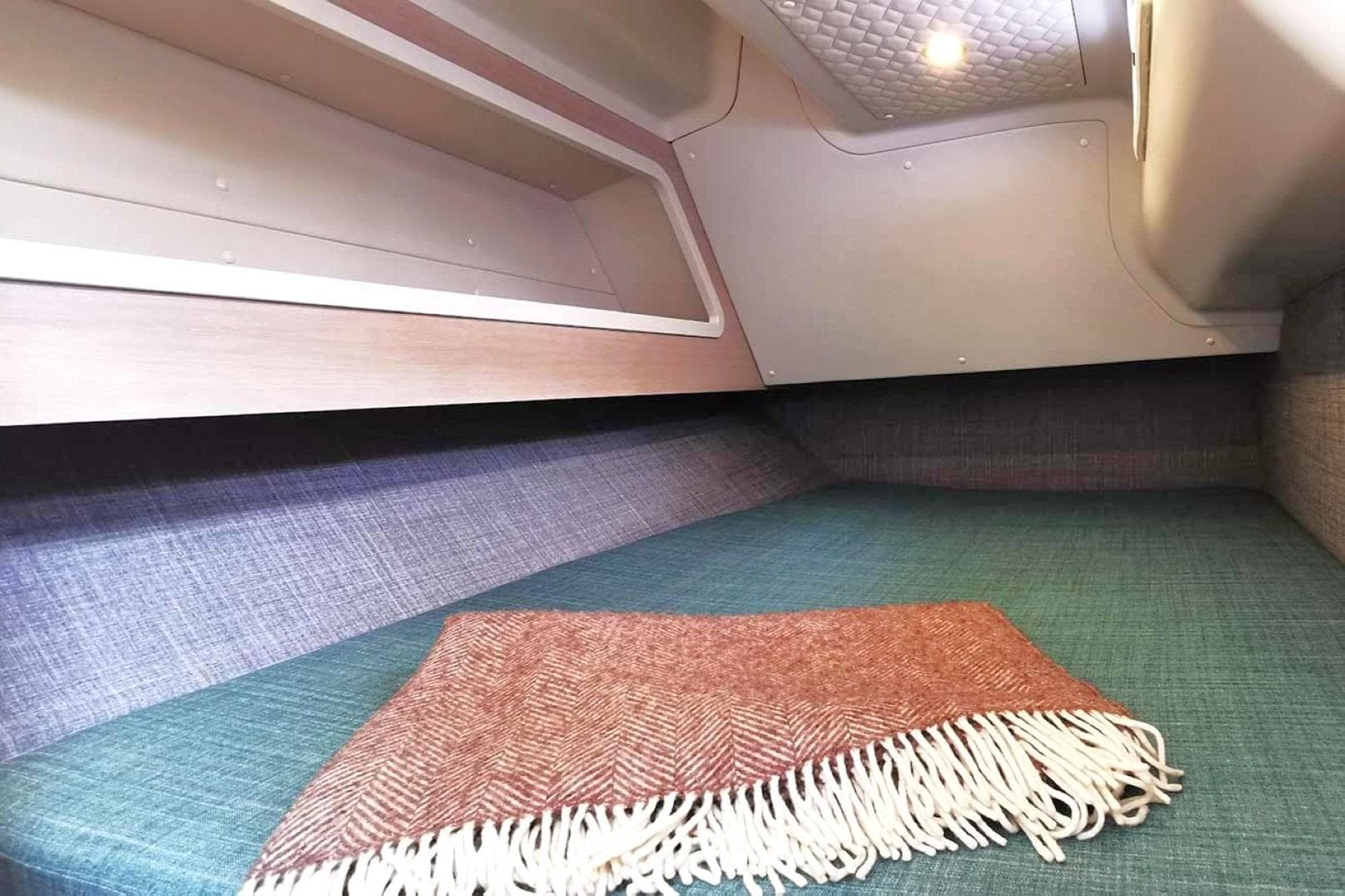 Cozy interior cabin of 2025 Shogun 43 with blanket on bed.
