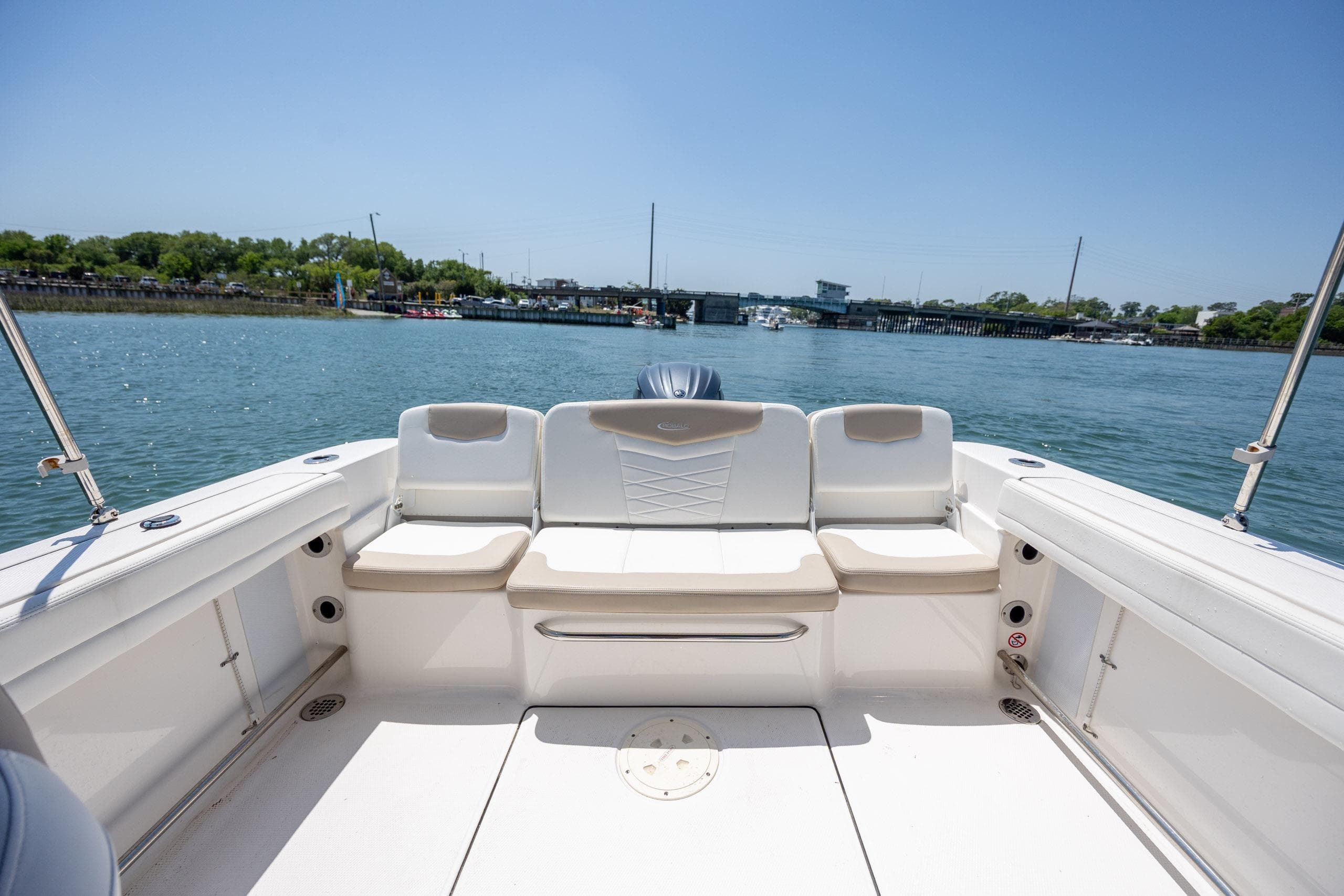 2024 Robalo R207 Dual Console boat interior with seating, on a sunny day by the water.