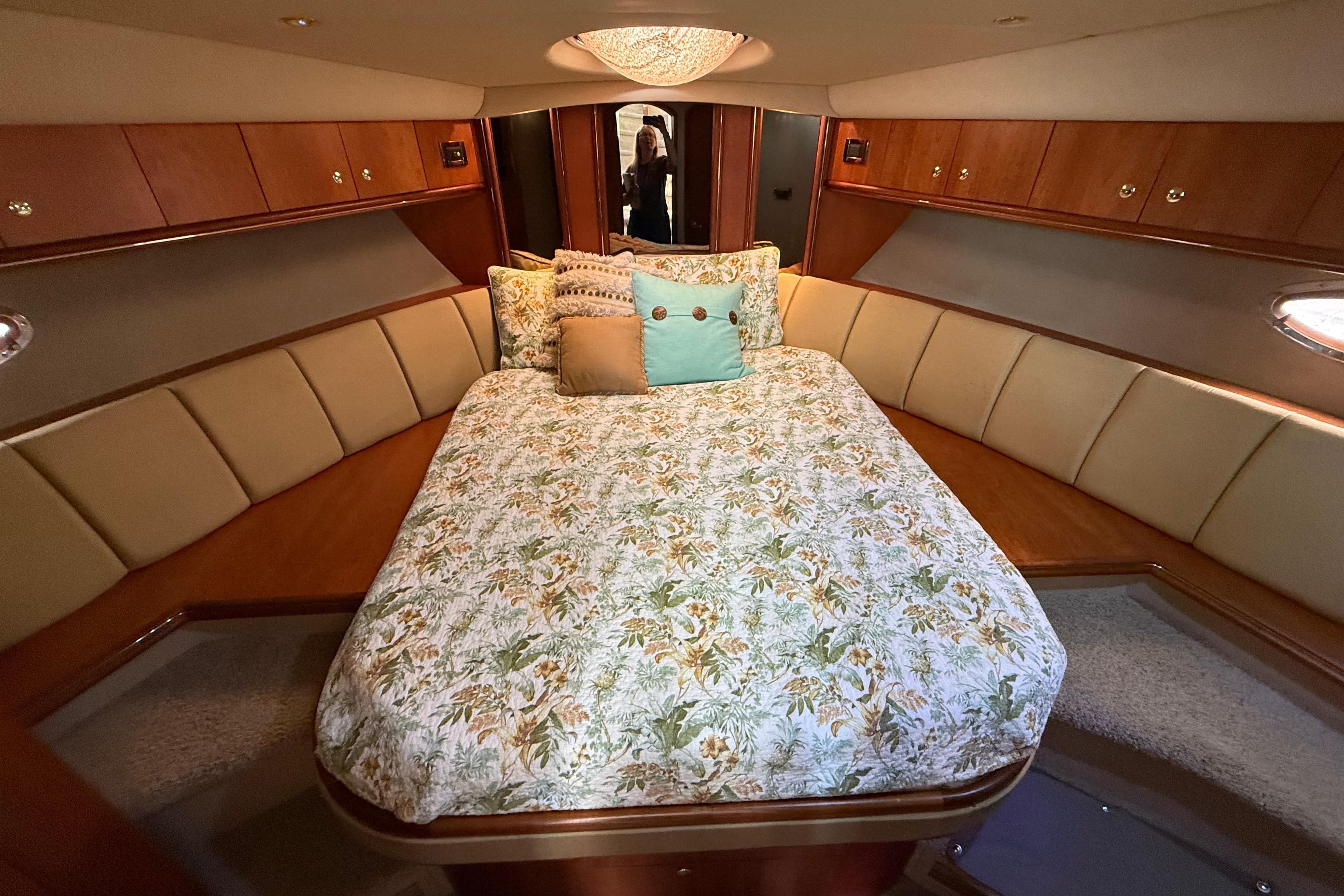 Luxurious bedroom interior of 2002 Cruisers Yachts 4450 Express Motoryacht with floral bedding.