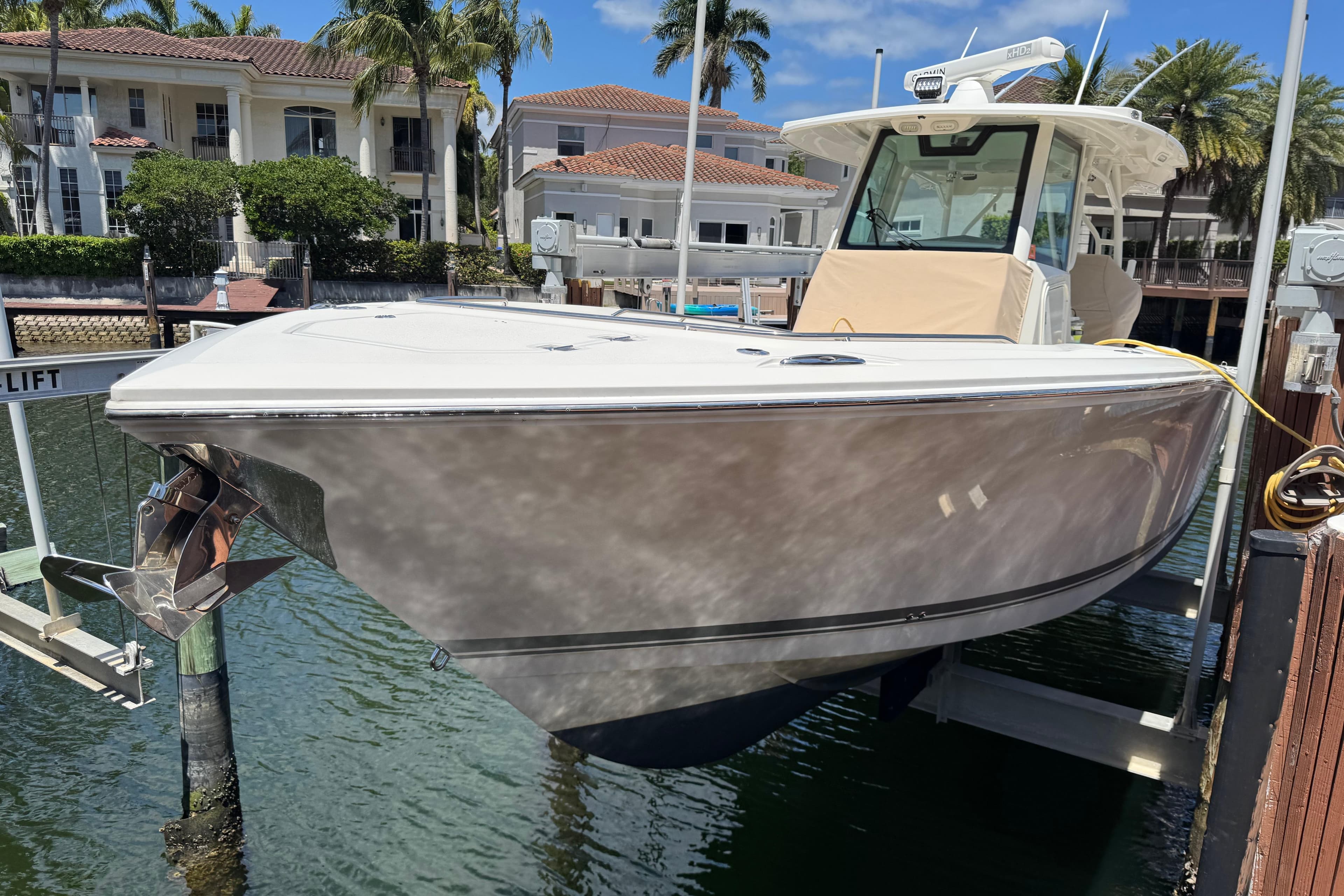 2019 Sailfish 360 CC boat docked at marina with waterfront homes in background.