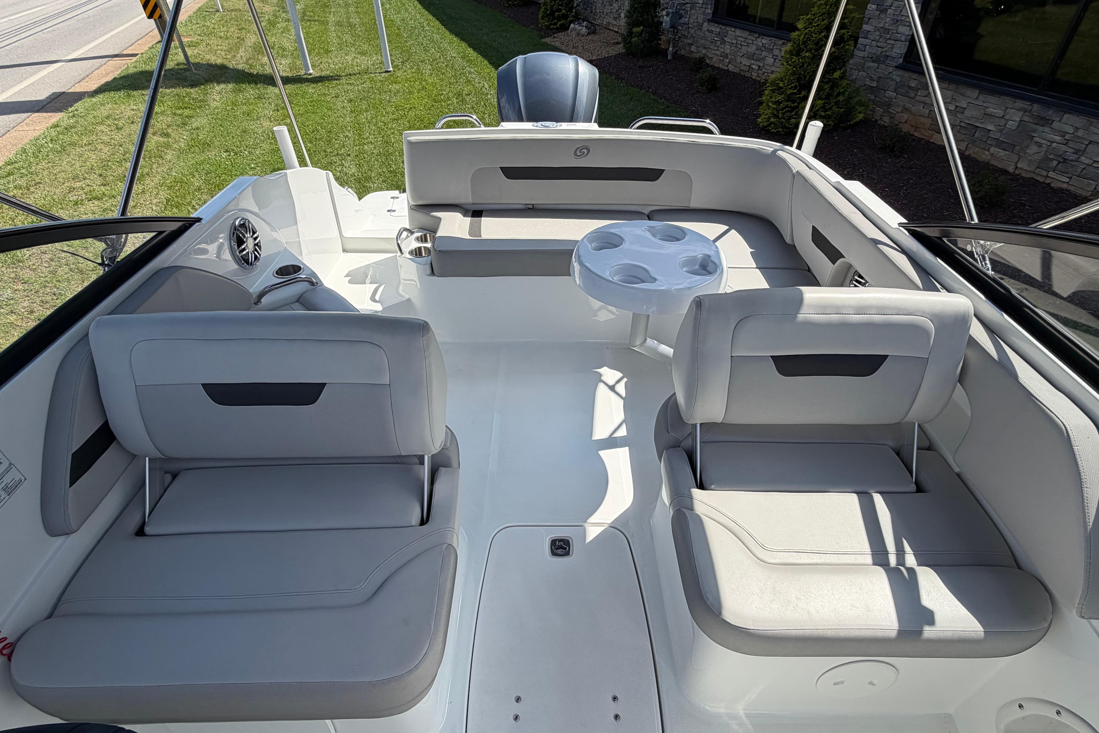 2023 Hurricane SunDeck 235 OB boat interior with seating and table, showcasing modern design.