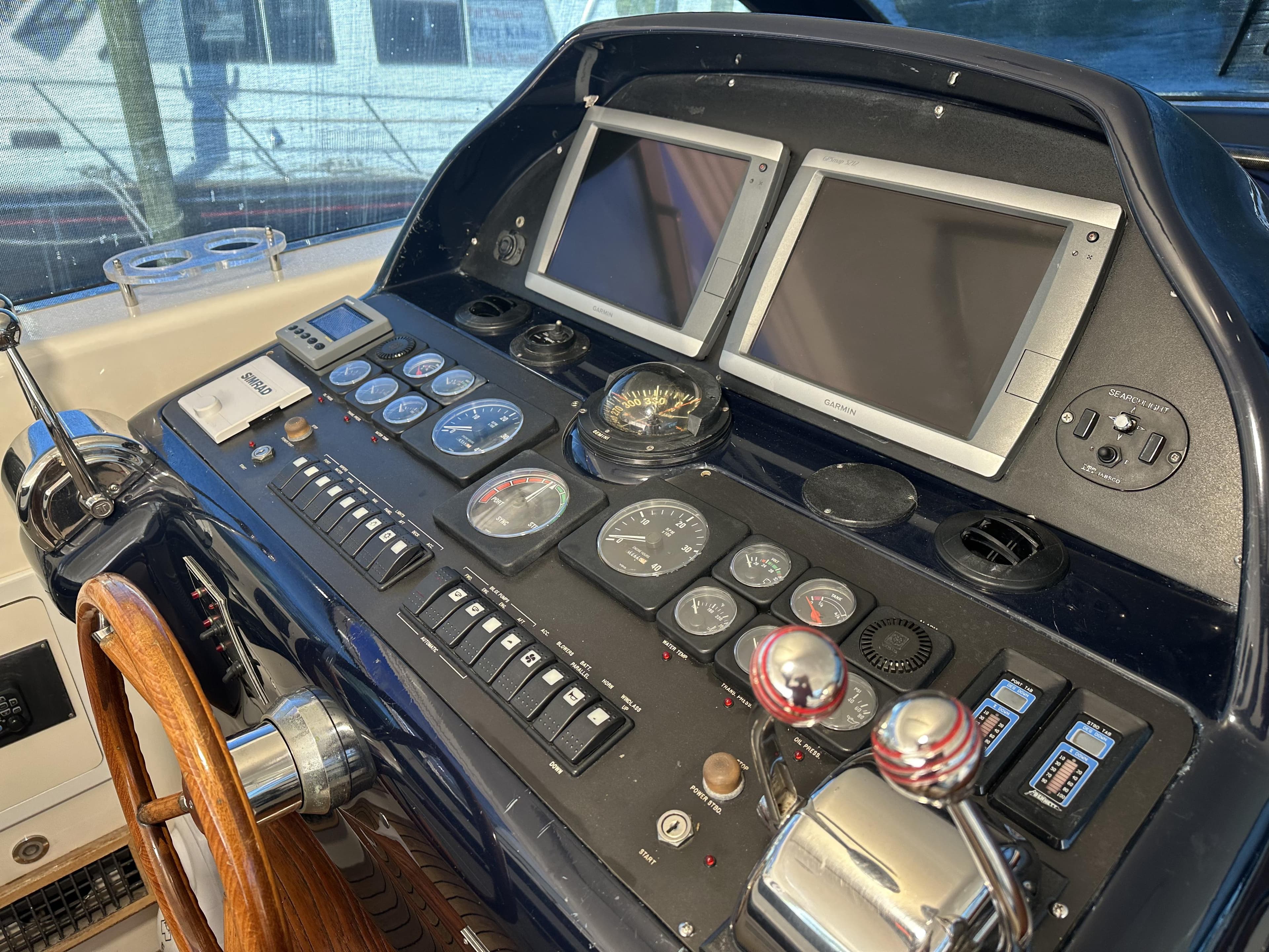 Control panel of a 1999 Uniesse 57 Open yacht with dual screens and gauges.