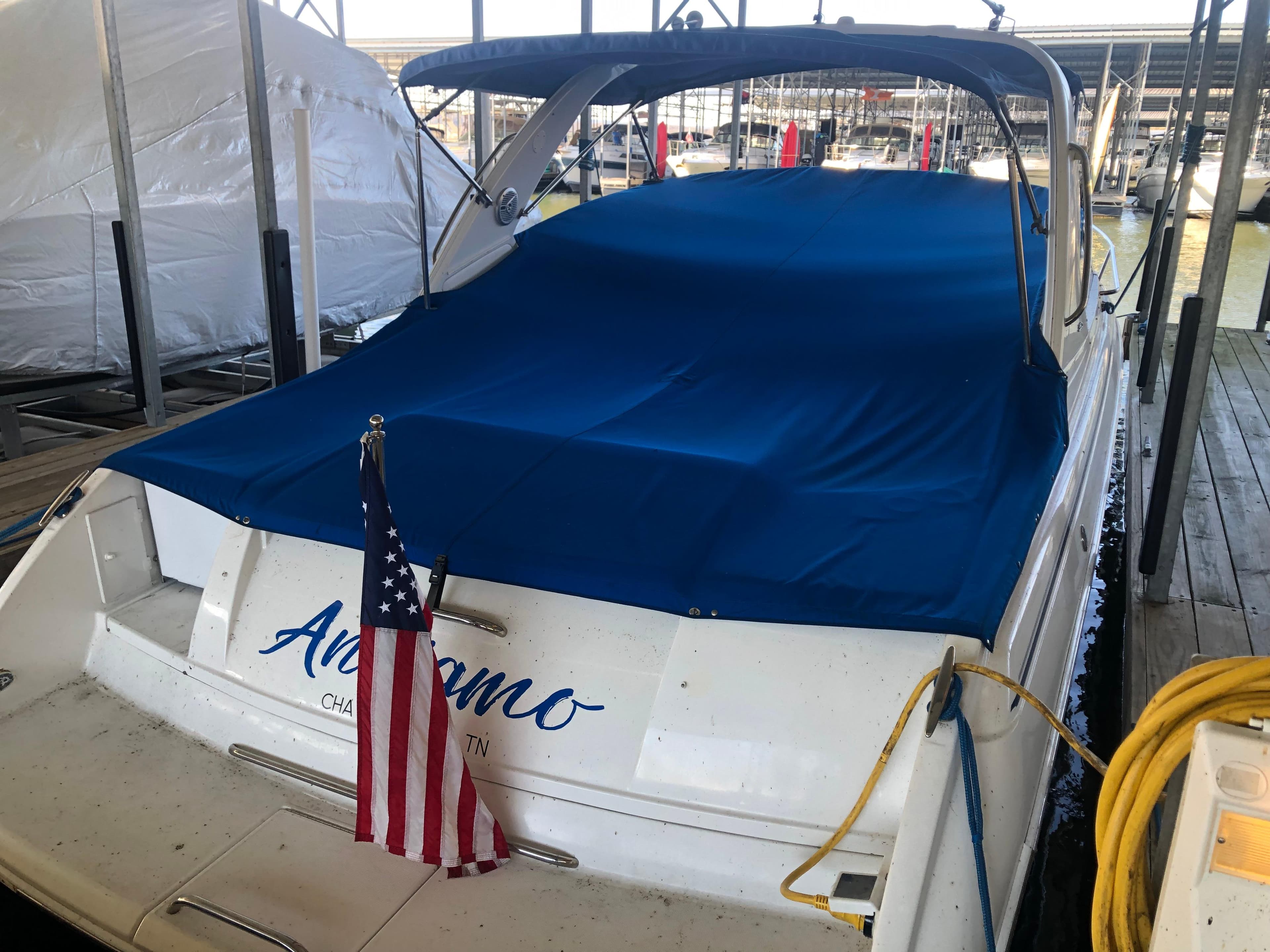 2004 Formula 330 Sun Sport boat docked with blue cover and American flag.