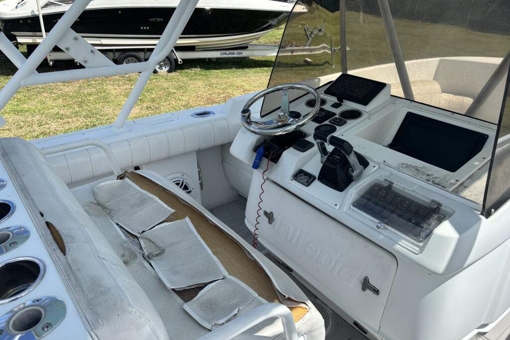 2000 Intrepid 322 Cuddy boat cockpit with steering wheel and control panel.