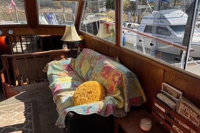 Cozy 1981 Uniflite MY interior with colorful quilted sofa and marina view.