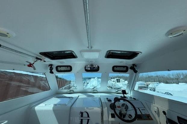 Interior view of 1999 Mainship Pilot 30 Sedan boat cockpit with steering wheel.